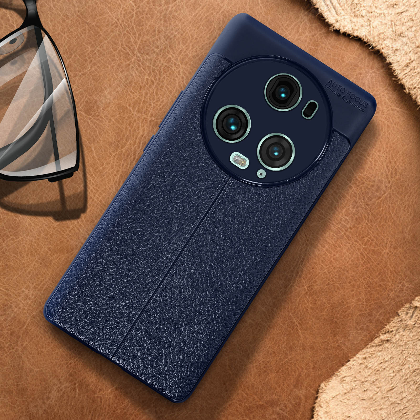 Una custodia per telefono blu navy su una superficie in pelle marrone, che mostra tre obiettivi della fotocamera.