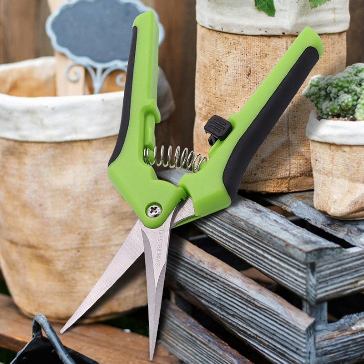 Grüne und schwarze Gartenschere. Edelstahlklingen. Holzrahmen Hintergrund.