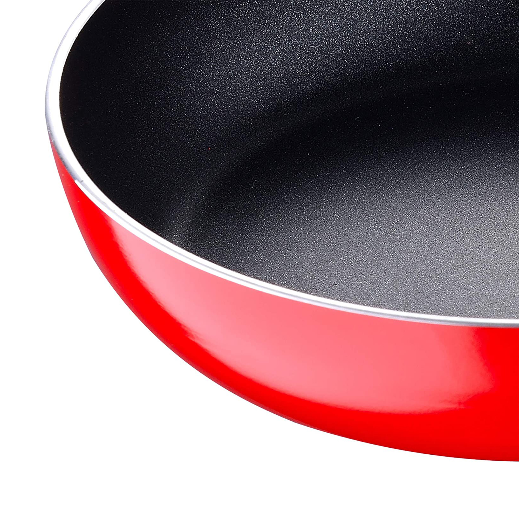 Un primer plano del borde de una sartén roja. El interior es negro.
