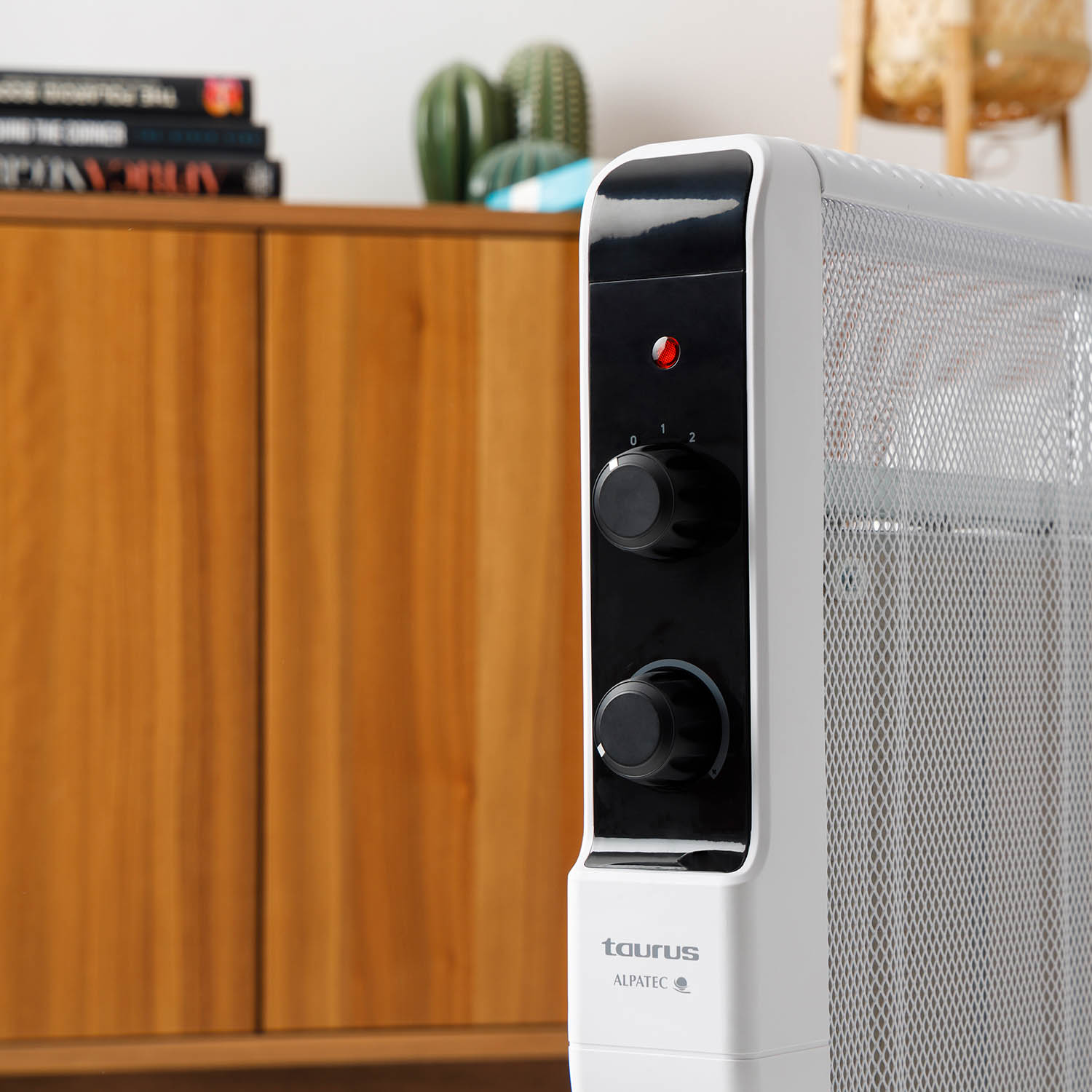 Zbliżenie grzejnika elektrycznego z elementami sterującymi, czarnym panelem i czerwonym światłem.