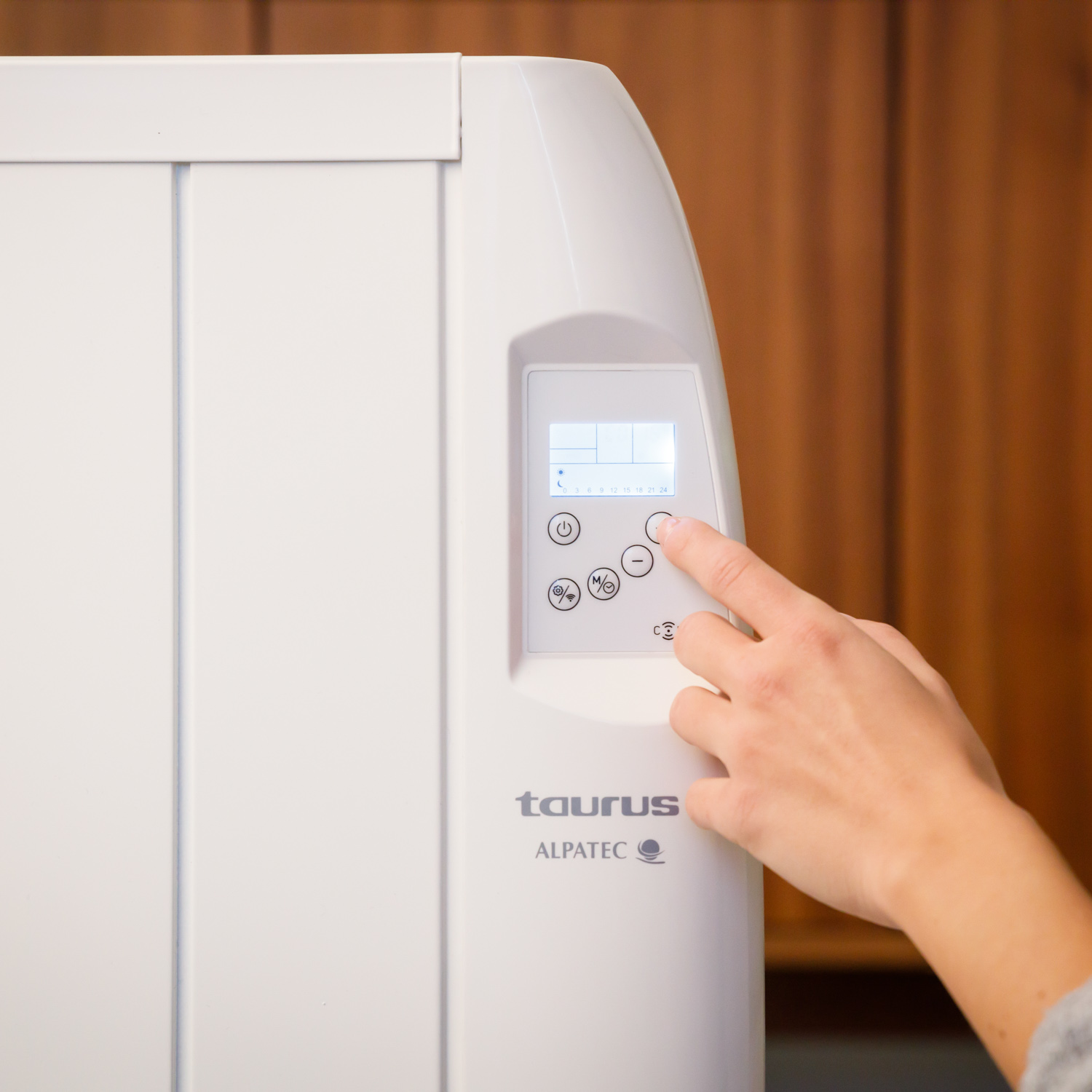 Termosifone elettrico bianco con una mano che interagisce con il pannello di controllo.