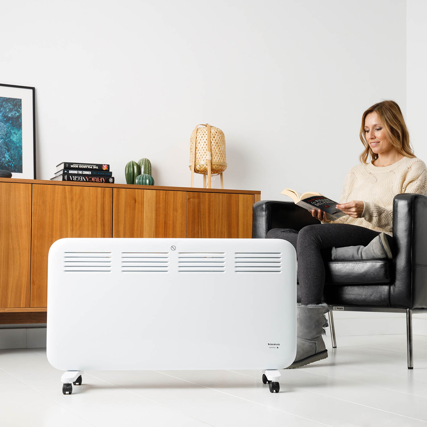 Un radiador eléctrico blanco con flechas que indican el flujo de calor. Tiene ventilaciones verticales.