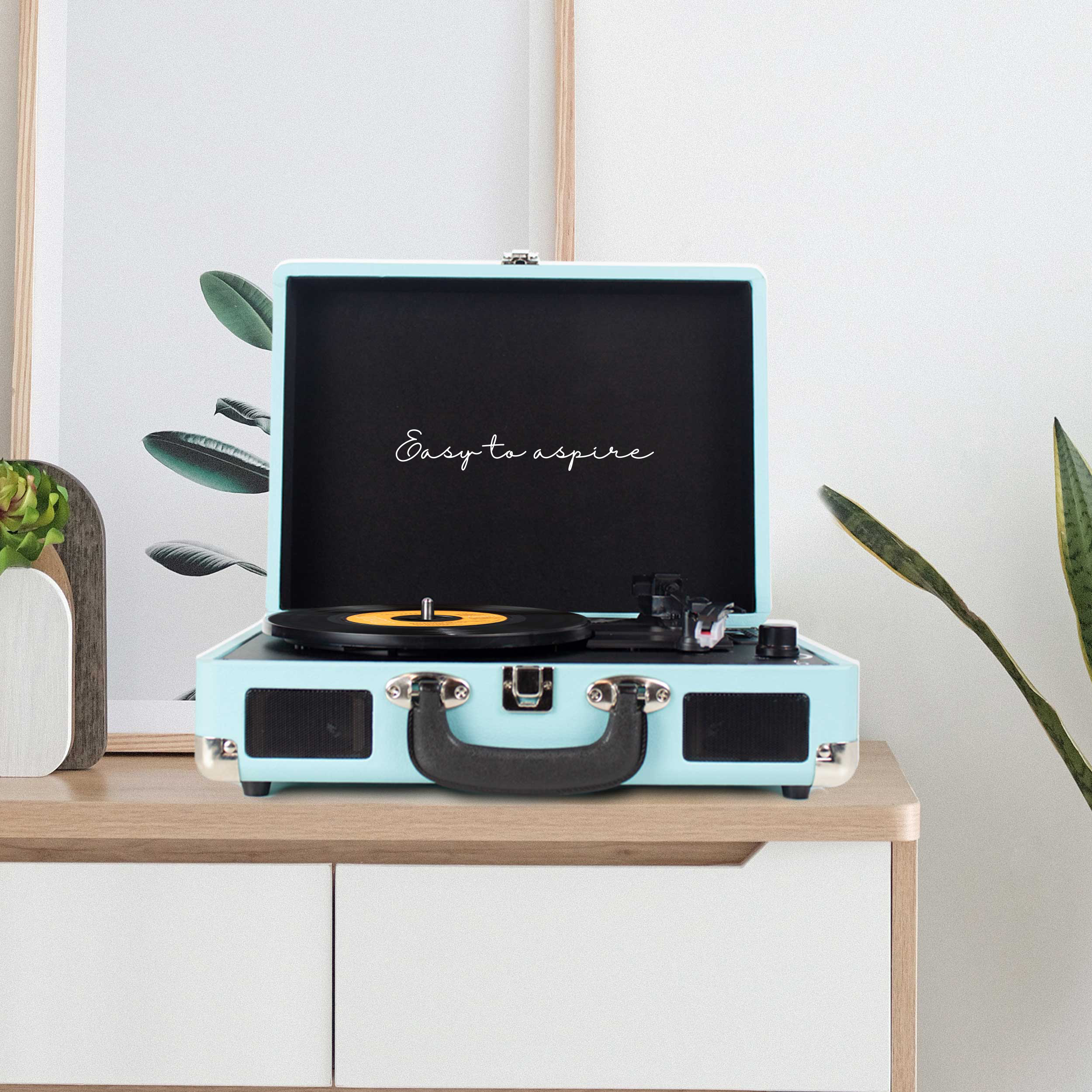 Niebieski gramofon stojący na drewnianej szafce.
