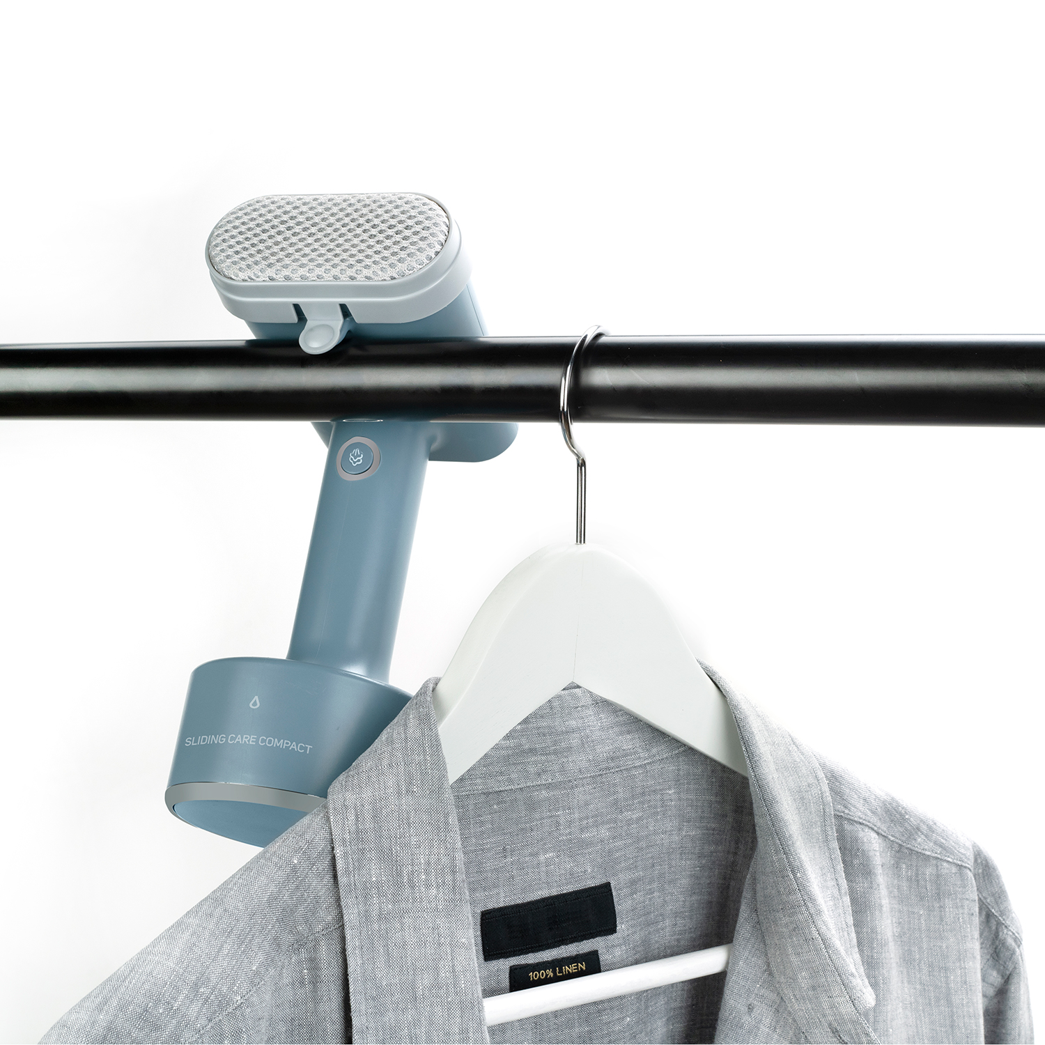 Un vaporizador de ropa azul y gris colgado de una barra. Una camisa cuelga debajo.