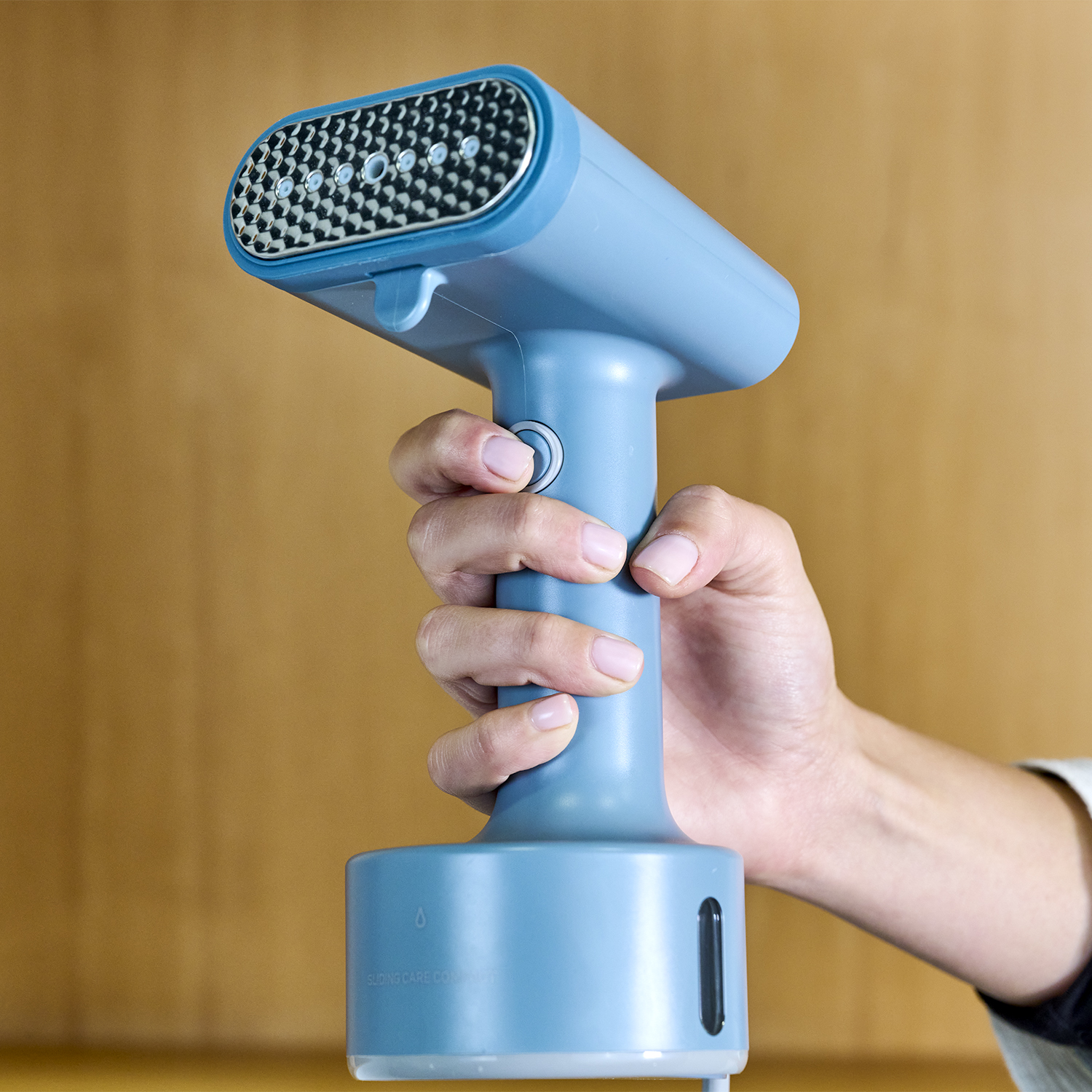 Una mano sosteniendo un vaporizador portátil azul con una cabeza de rejilla y un indicador de nivel de agua.