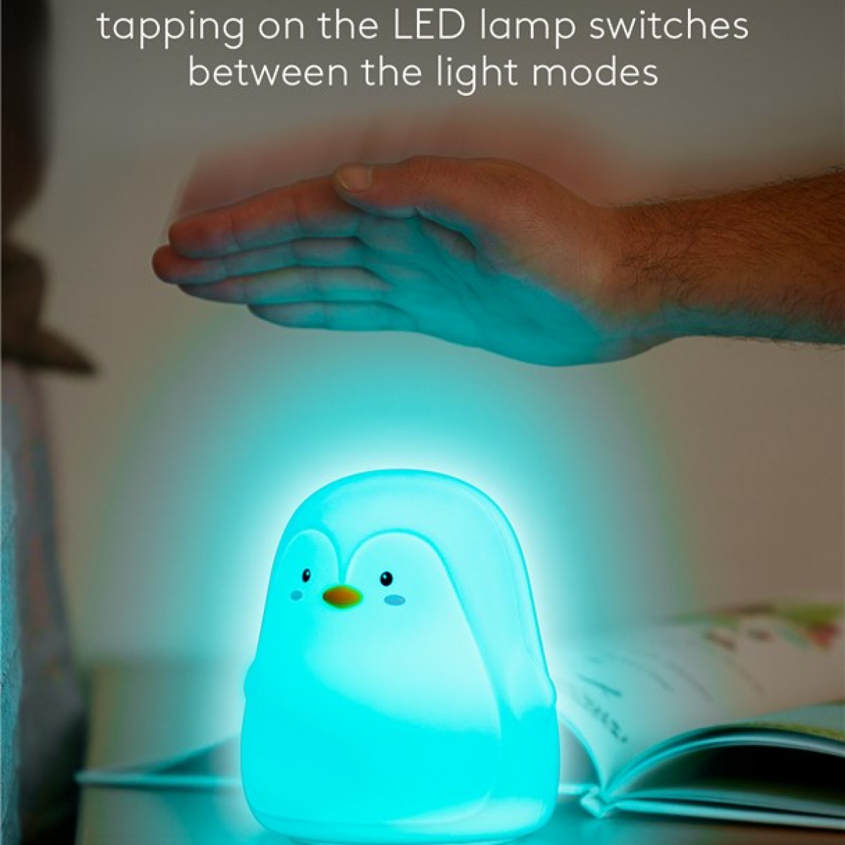 Pinguin-Lampe, blau beleuchtet, Hand darüber. Text: „Tippen auf die LED-Lampe schaltet…“