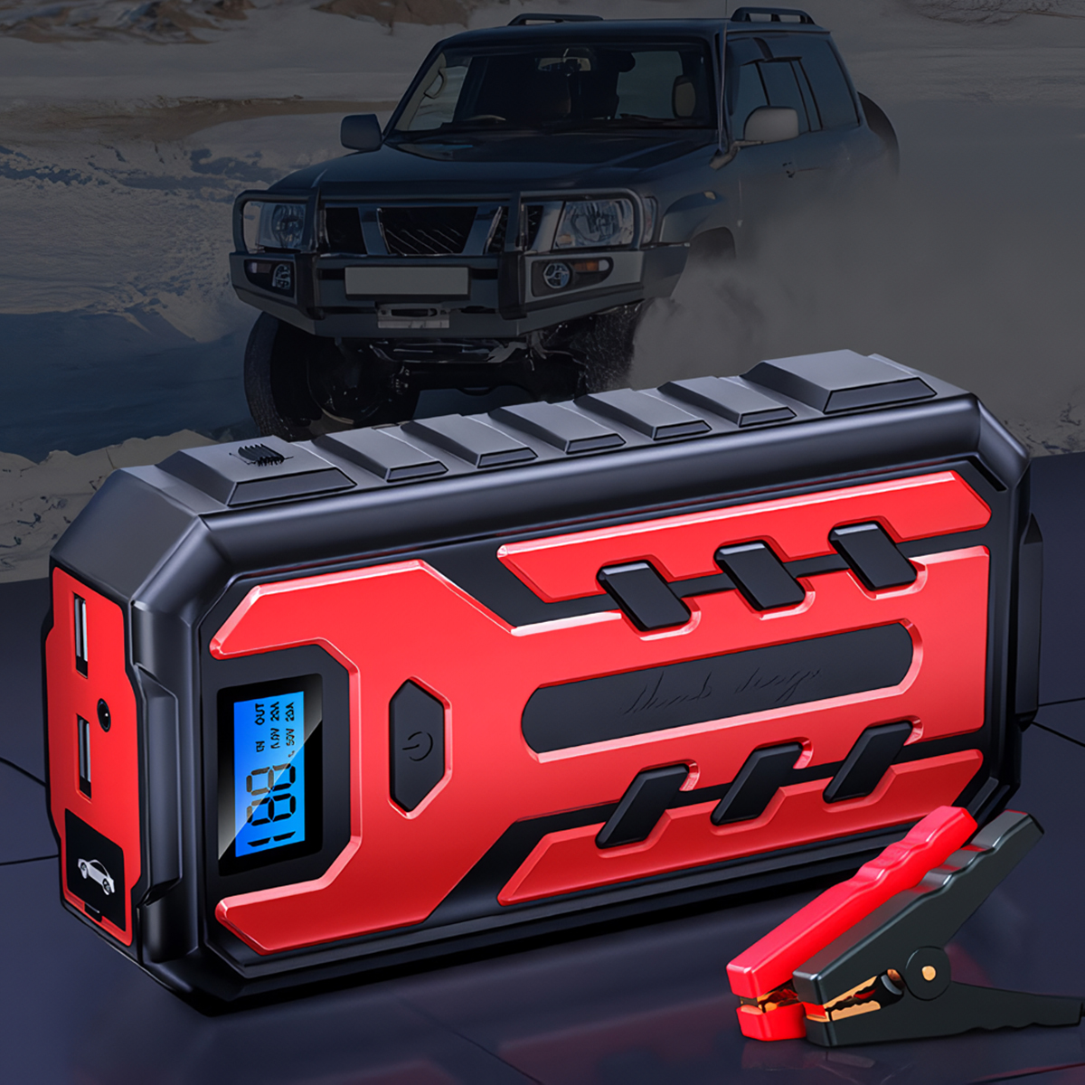 Arrancador de batería rojo y negro con pantalla digital y pinzas; SUV en el fondo borroso.