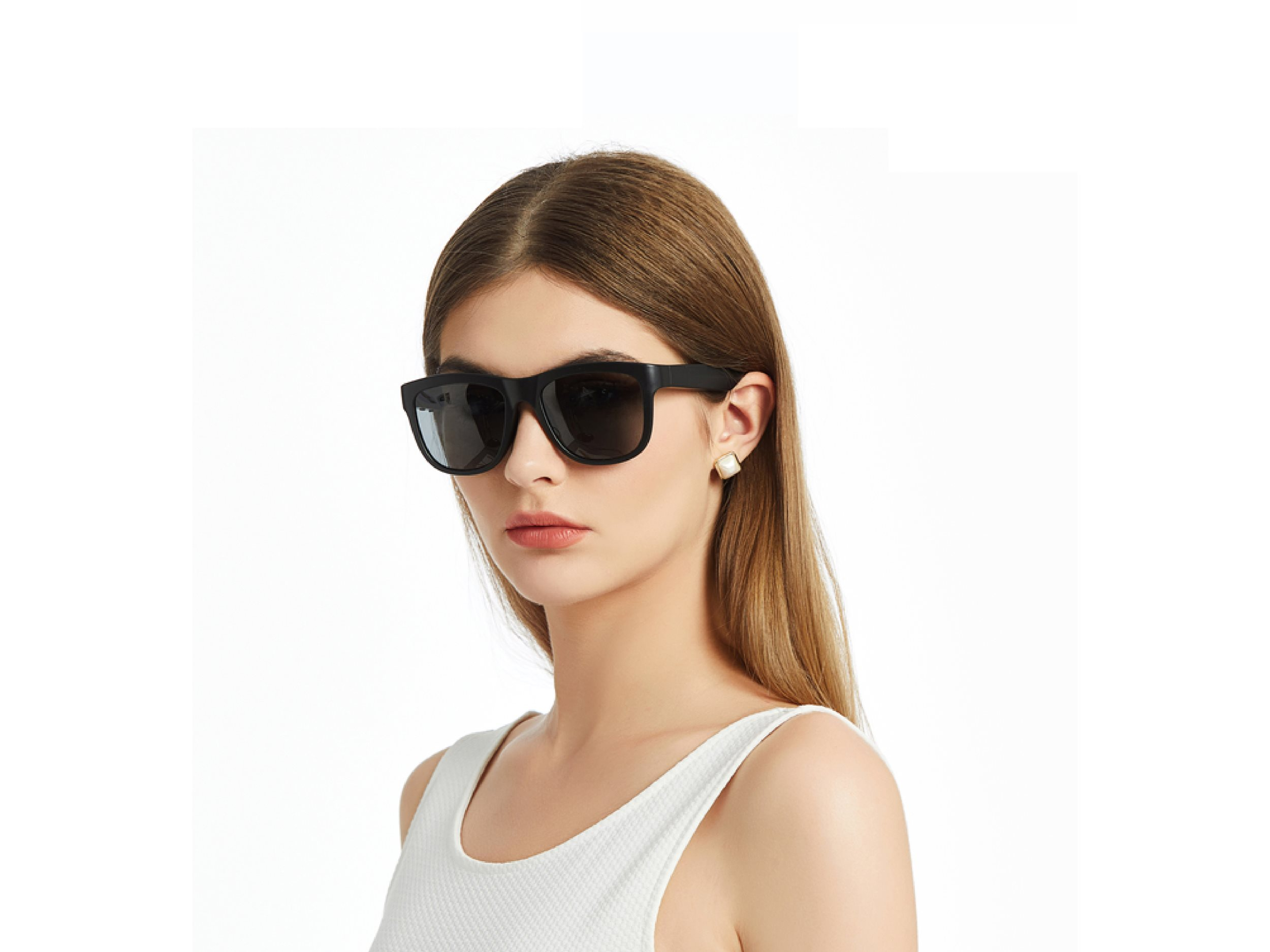 Eine Frau mit schwarzer Sonnenbrille und einem weißen Tanktop.