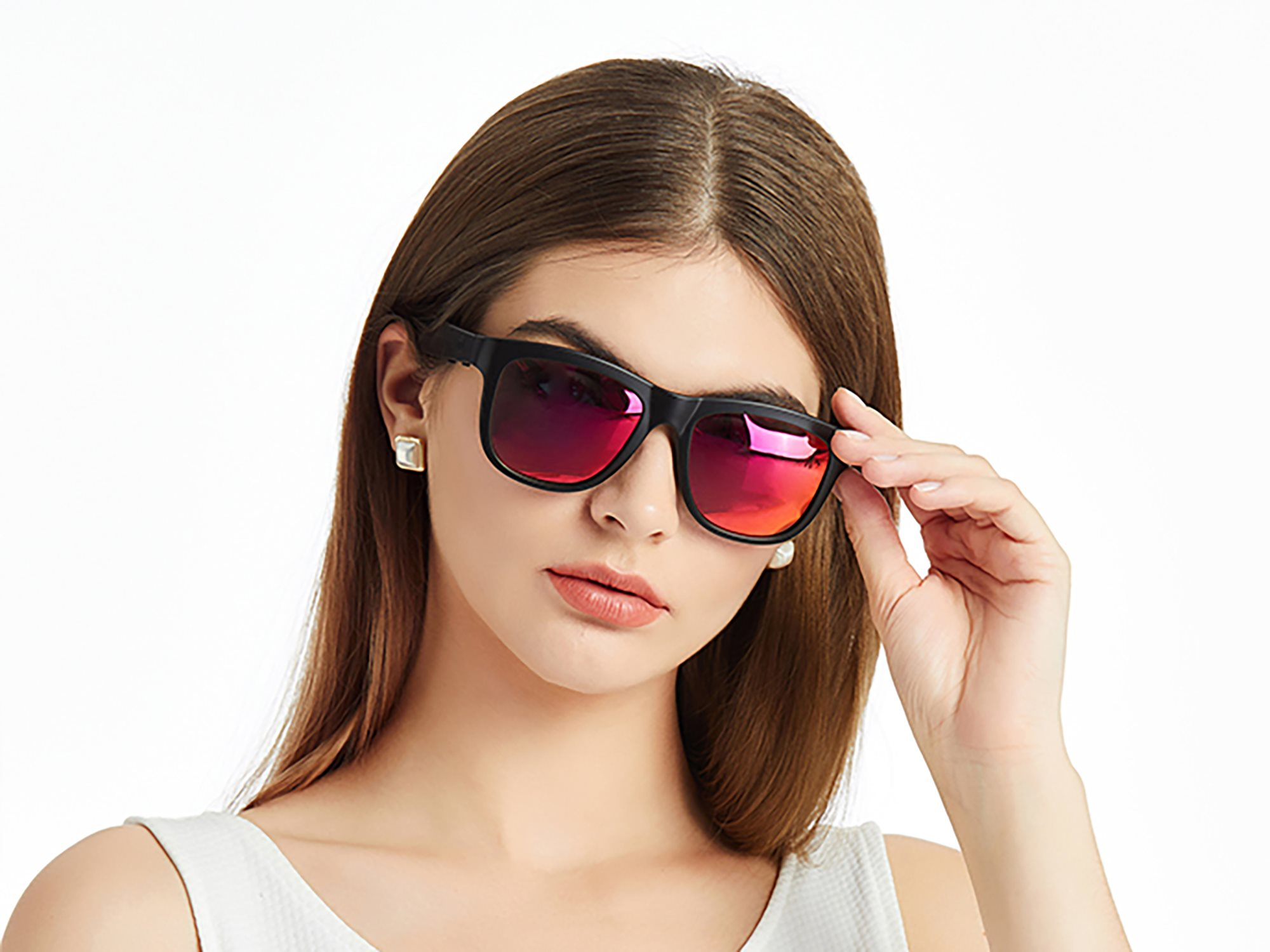 Frau mit schwarzer Sonnenbrille und roten Gläsern. Vor weißem Hintergrund.