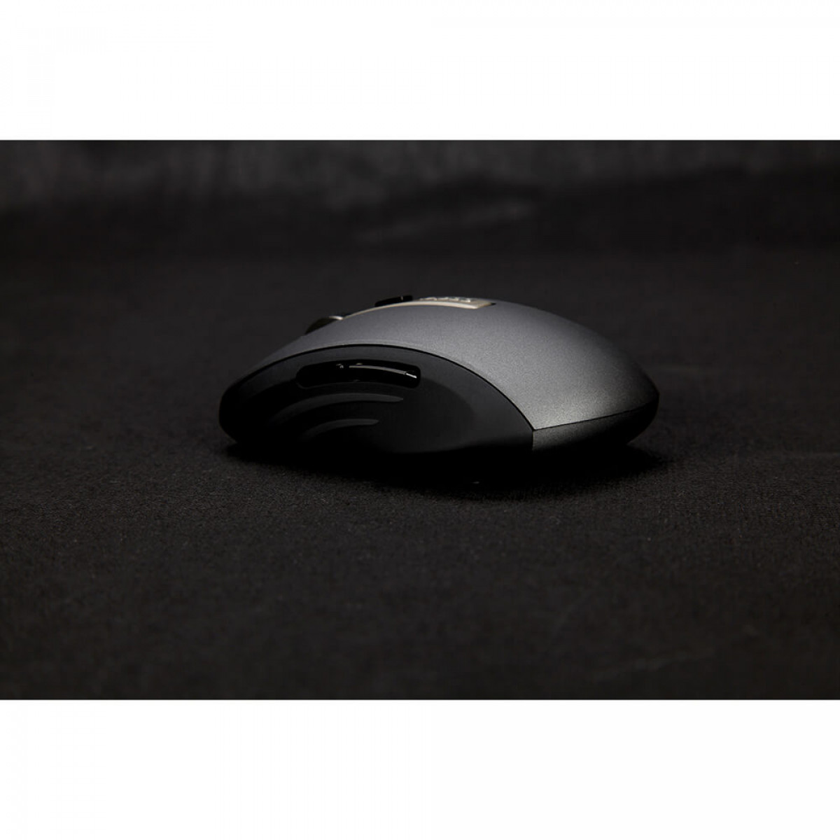Eine schwarze Computermaus auf einer schwarzen Oberfläche. Die Maus hat ein schlankes, gebogenes Design.