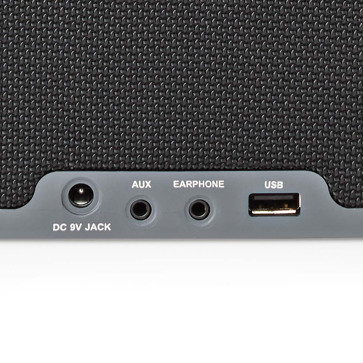 Close-up van een grijze luidspreker met ingangen: DC-aansluiting, aux, koptelefoon en USB.