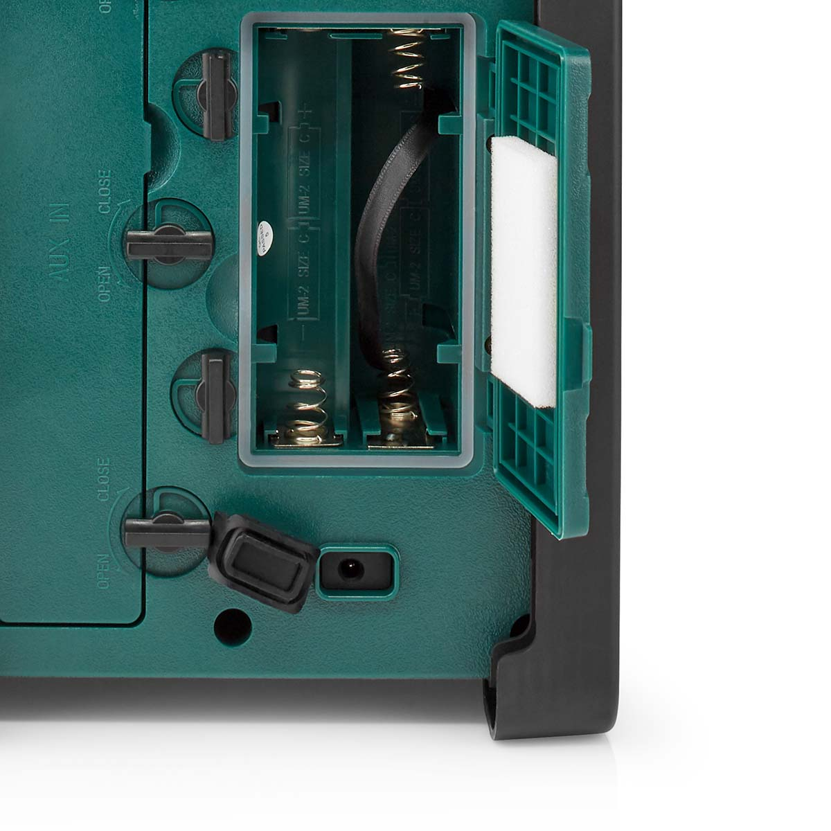 Wewnątrz zielonego pudełka: baterie, sprężyny i czarny pasek. Otwarta pokrywa.