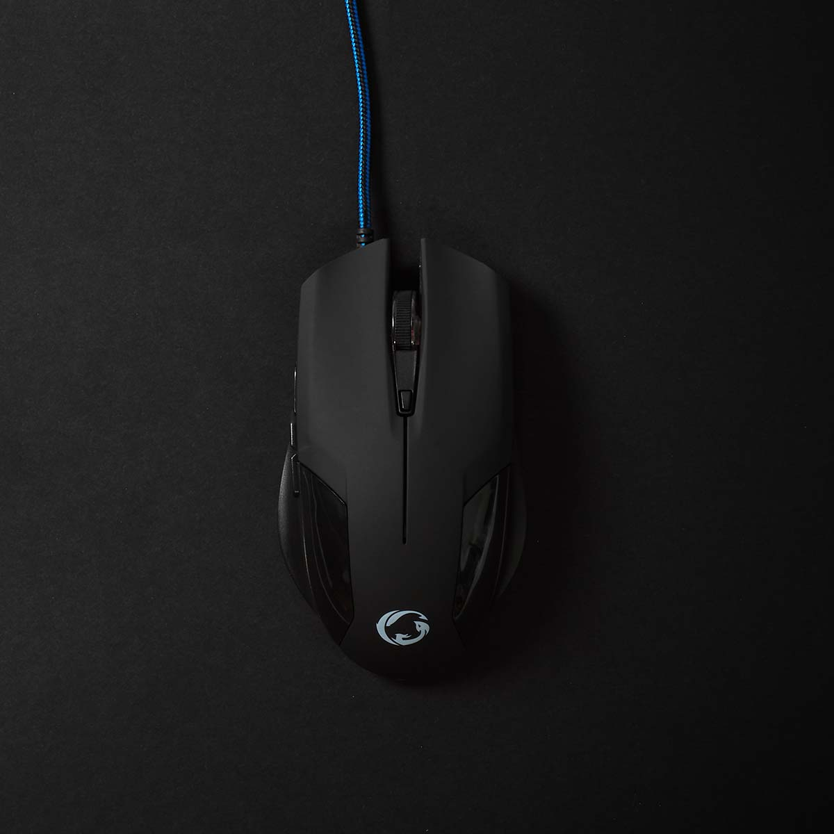 Schwarze Computermaus auf schwarzer Oberfläche. Sie hat ein Logo und ein blaues Kabel.