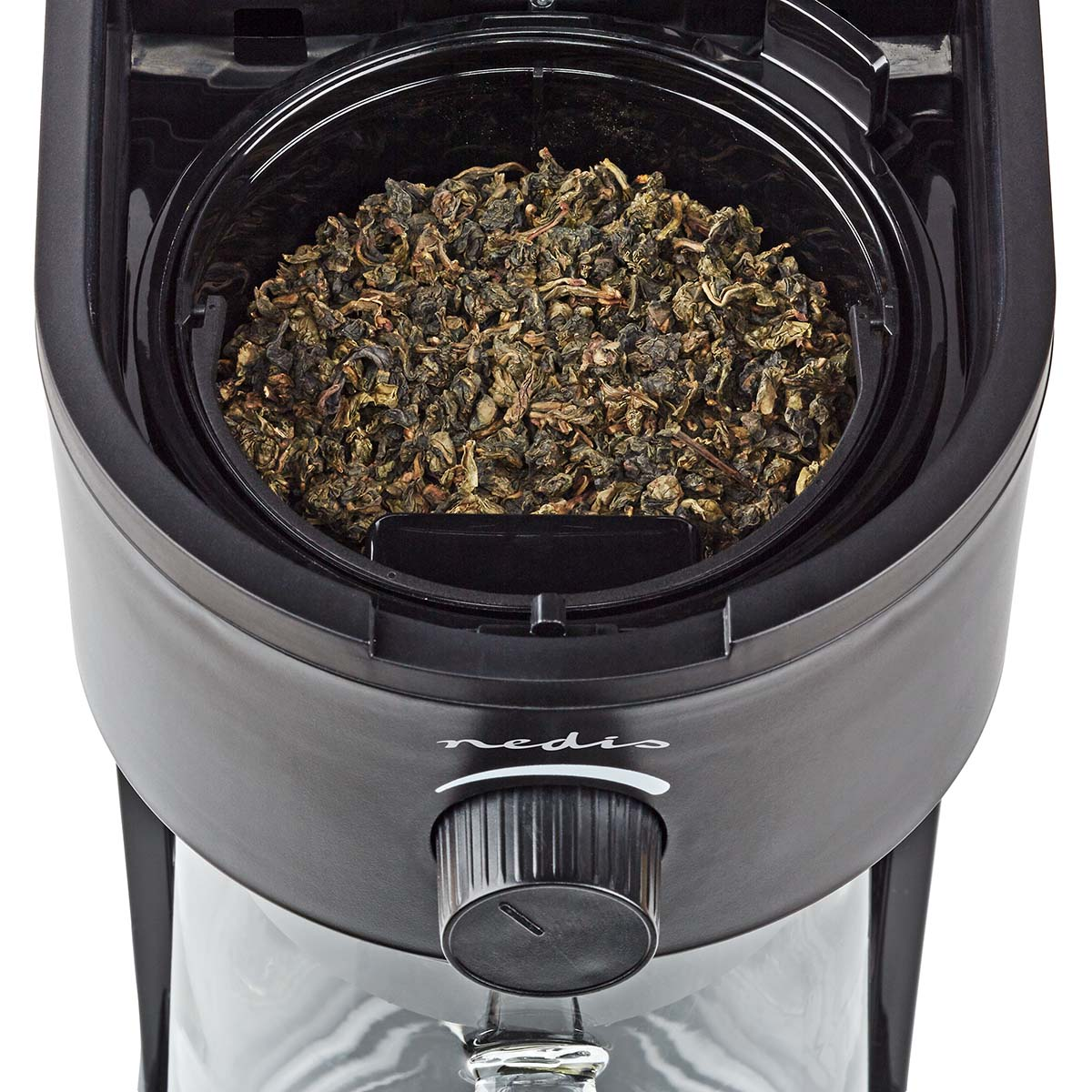 Primer plano de una máquina de té con un compartimento lleno de hojas de té secas.