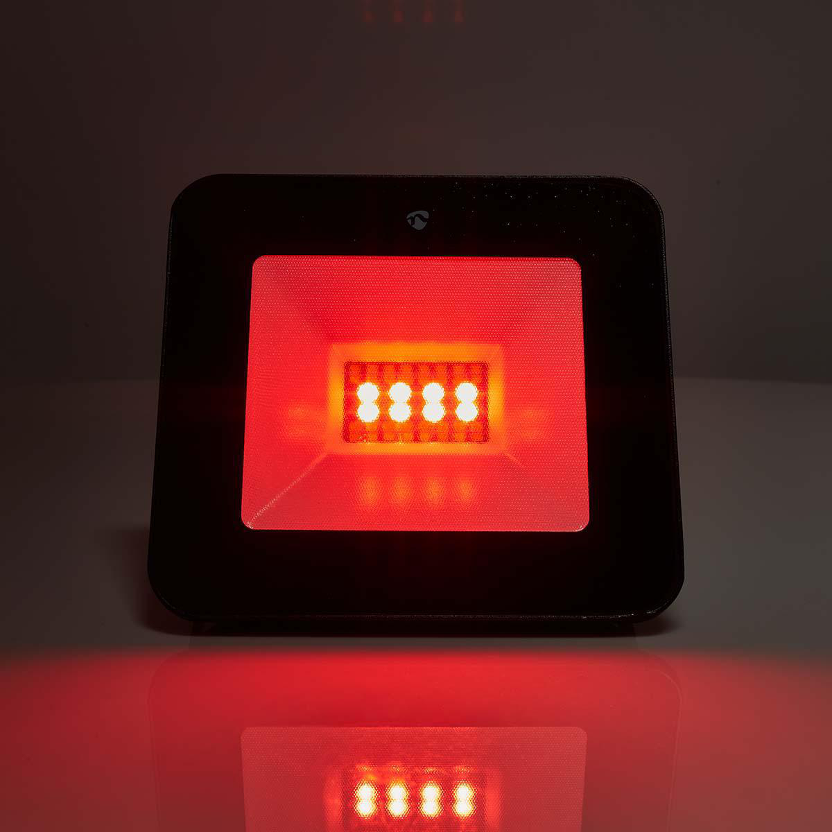 Een zwart vierkant apparaat met felrode lampjes. Het heeft een reflecterend oppervlak.