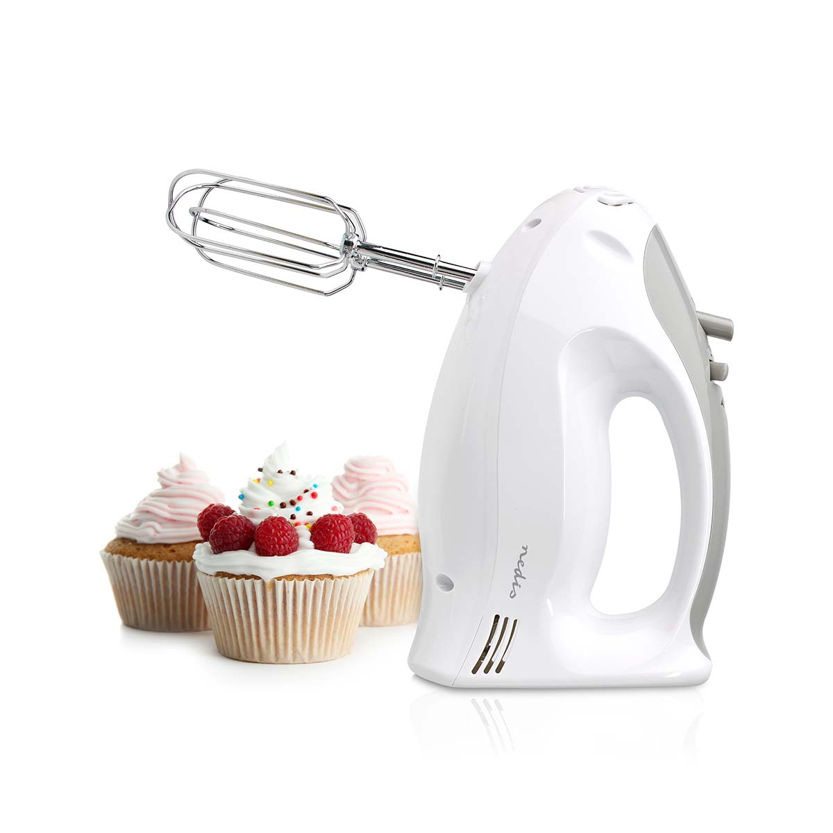 Batidora de mano blanca y gris con cupcakes y frambuesas sobre fondo blanco.