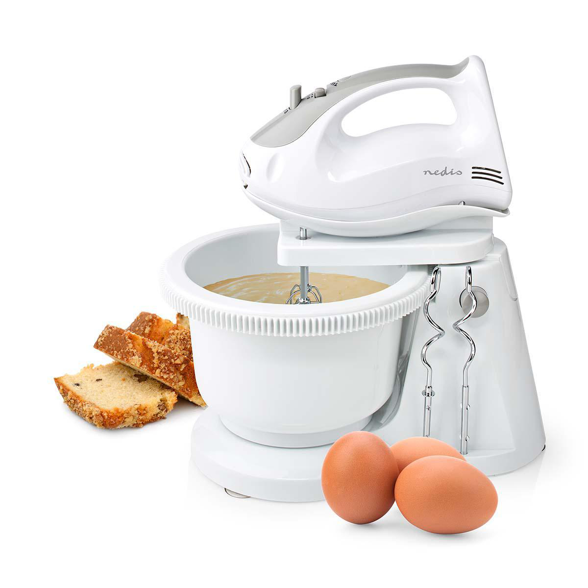 Witte handmixer met eieren, cakeschijfjes en een kom met beslag.
