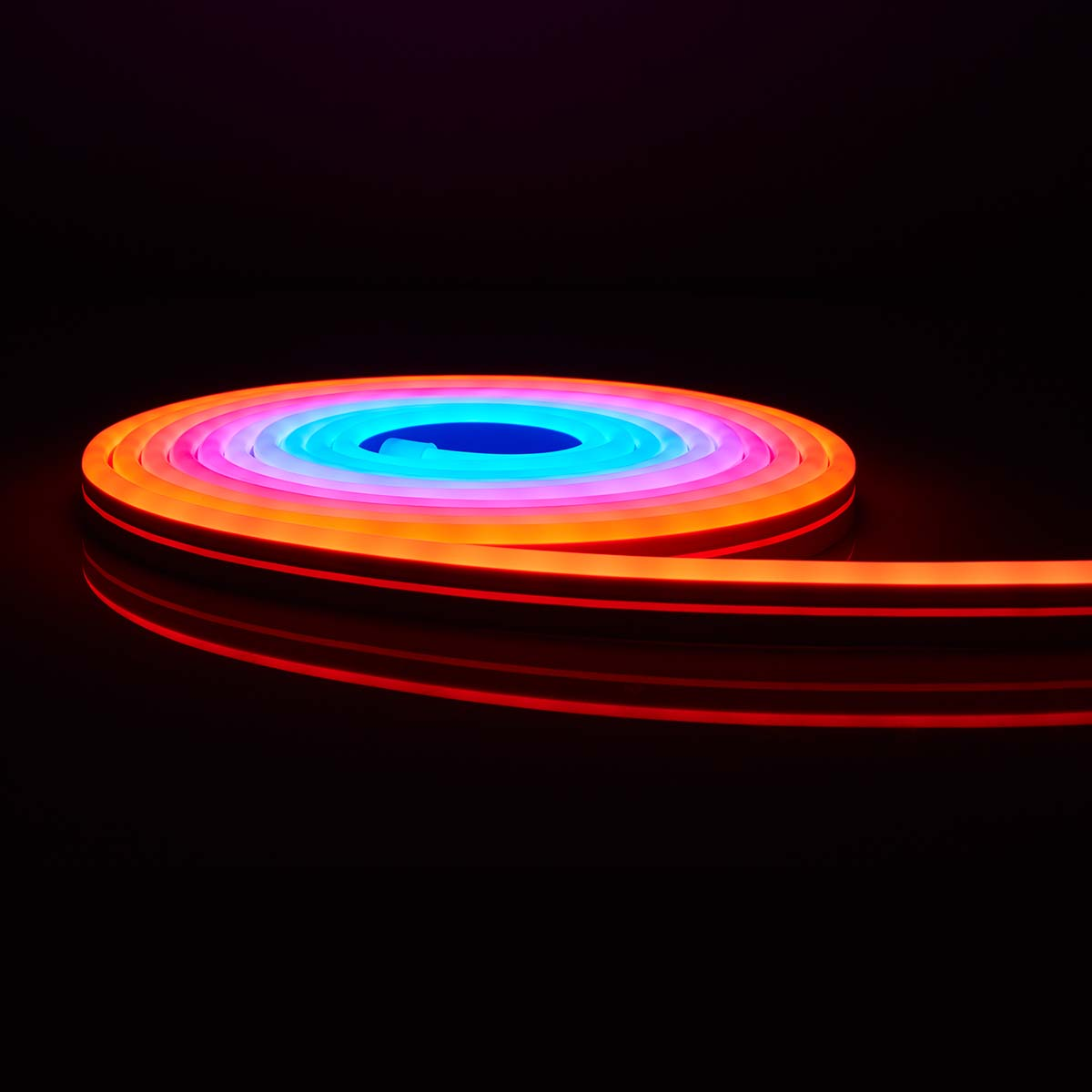 Opgerolde, flexibele neonlichtstrip, meerdere kleuren, op een zwarte achtergrond.