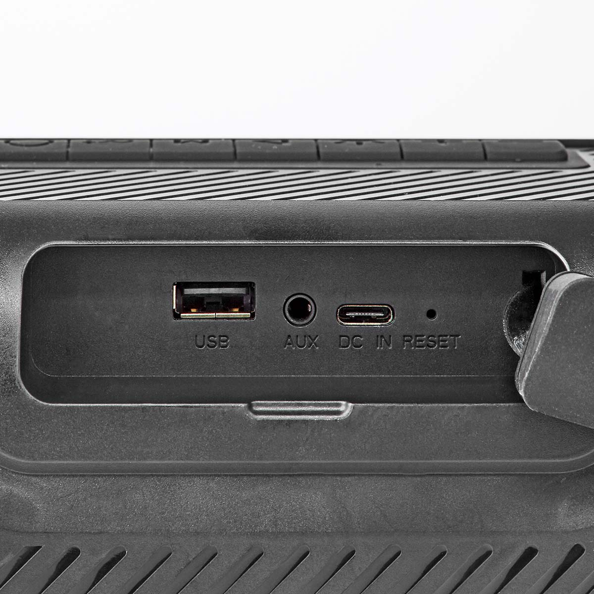 Un primo piano di un dispositivo nero con porte USB, AUX, DC e reset.