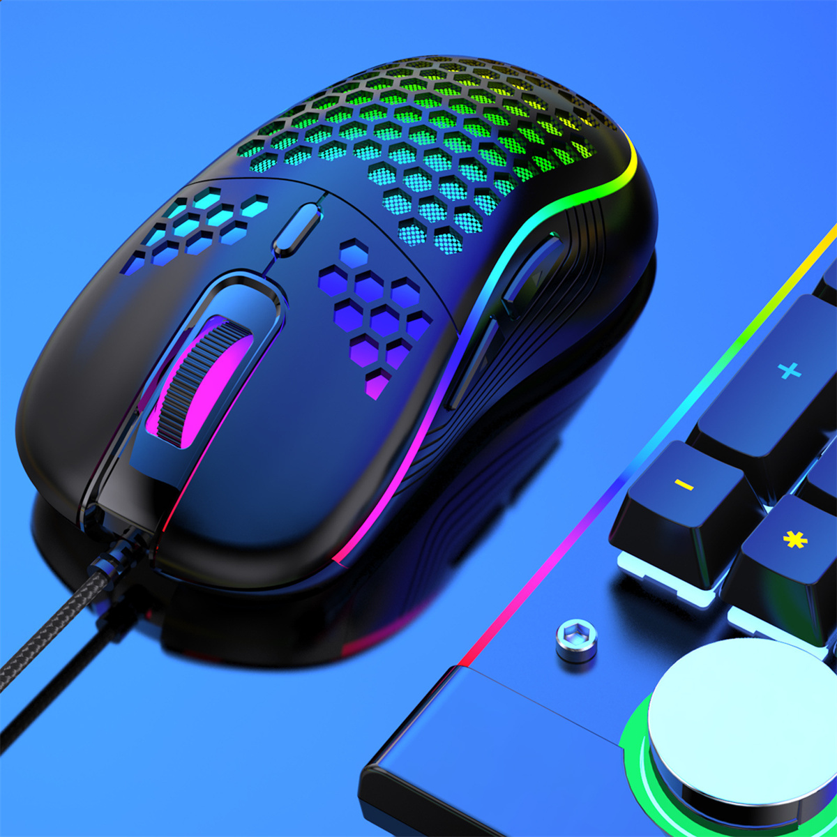 Un ratón gaming negro con iluminación RGB. Está colocado cerca de un teclado.