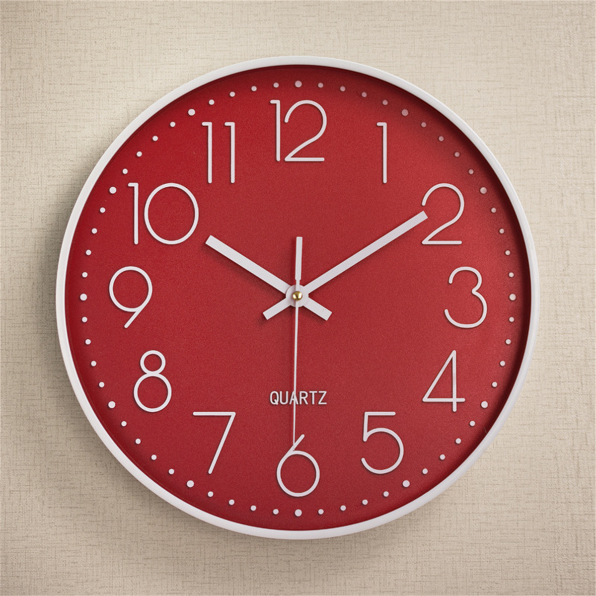 Reloj de cuarzo rojo con manecillas y números blancos, que muestra la hora cerca de la 1:30.