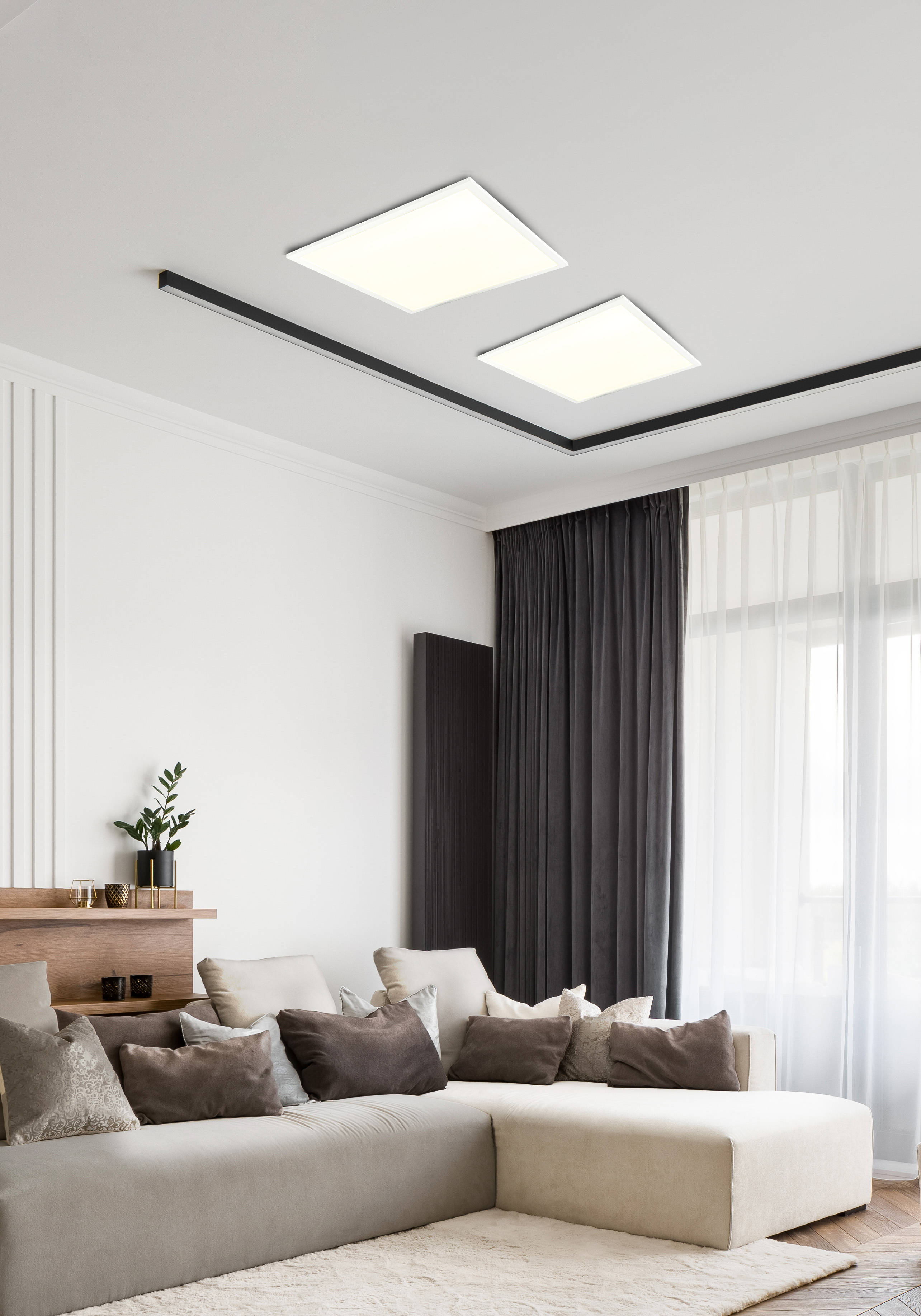 Modernes Wohnzimmer mit Sofa, zwei Deckenleuchten und Fenster.