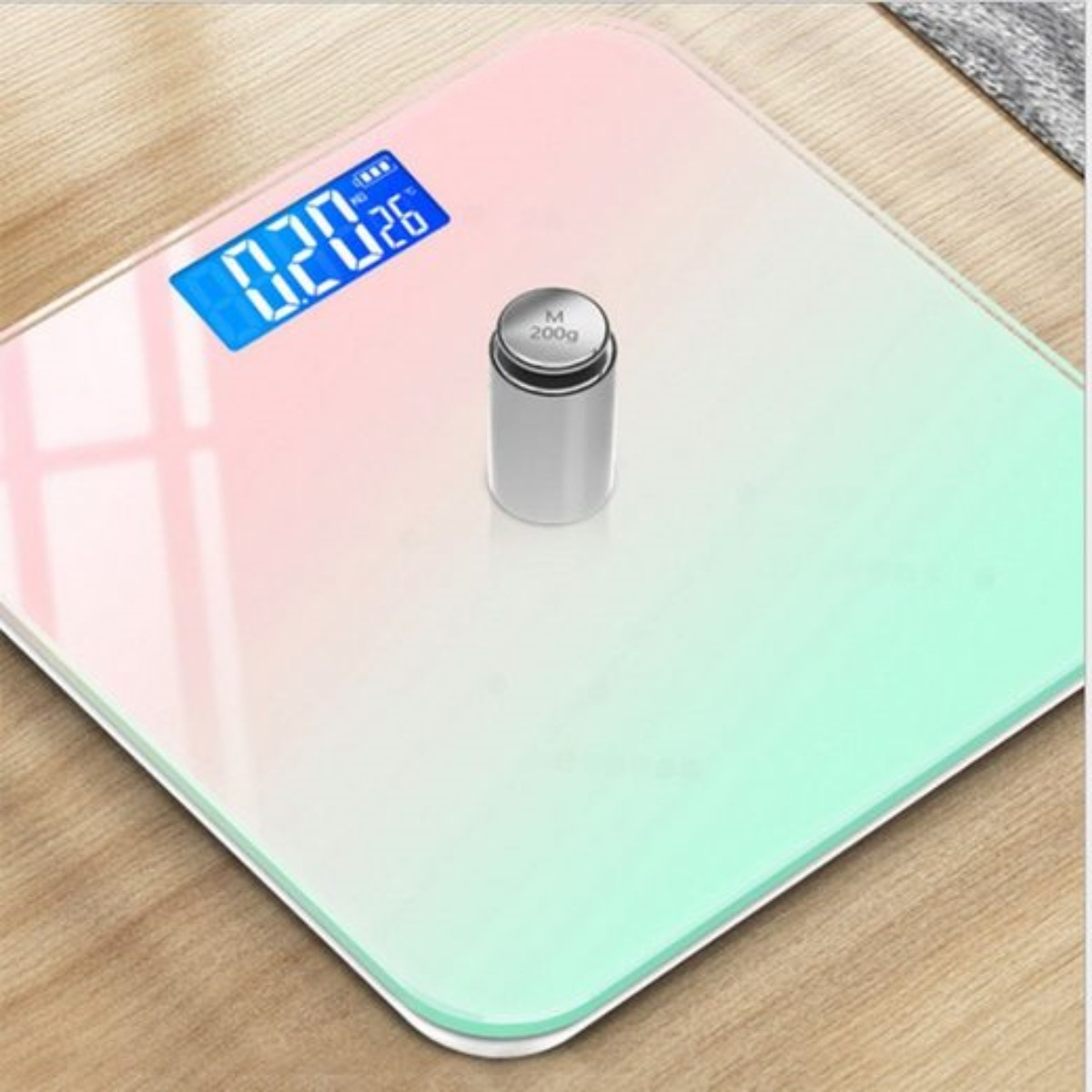 Digitale Waage mit Gewicht, Farbverlauf von Rosa zu Grün.