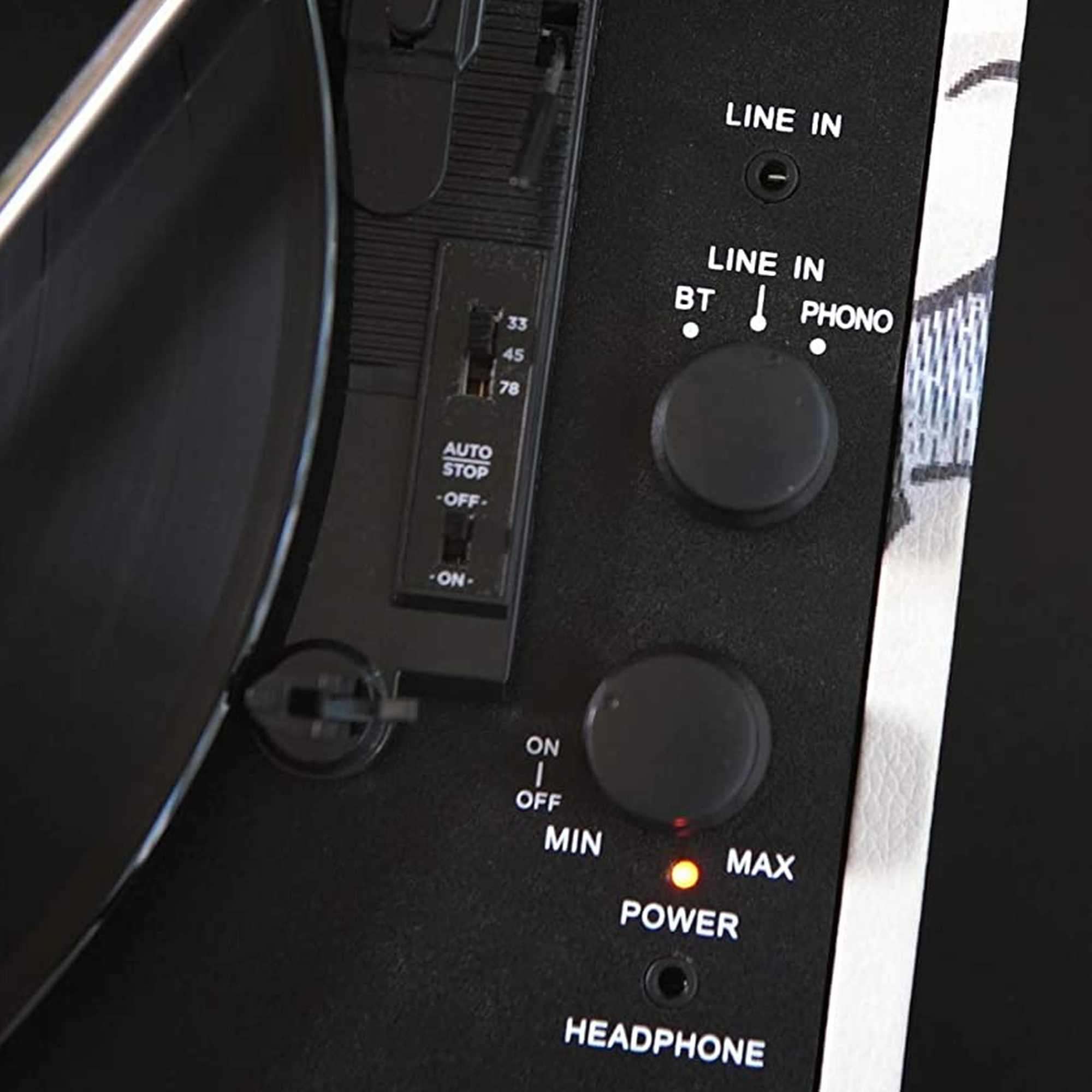 Primer plano del panel de control de un tocadiscos. Tiene botones, interruptores y etiquetas para los controles.