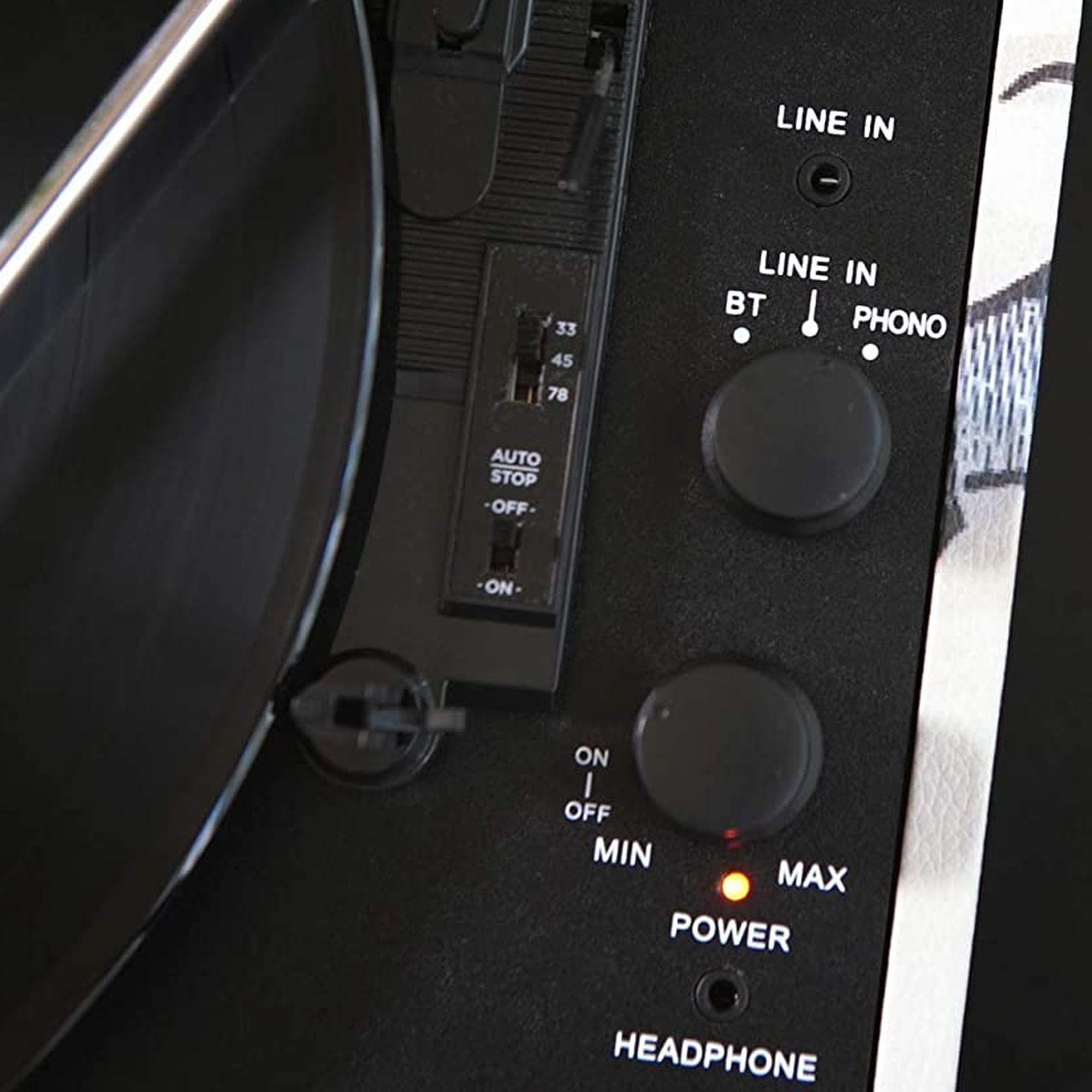 Primer plano del panel de control de un tocadiscos. Se ven botones e interruptores, con una luz roja.