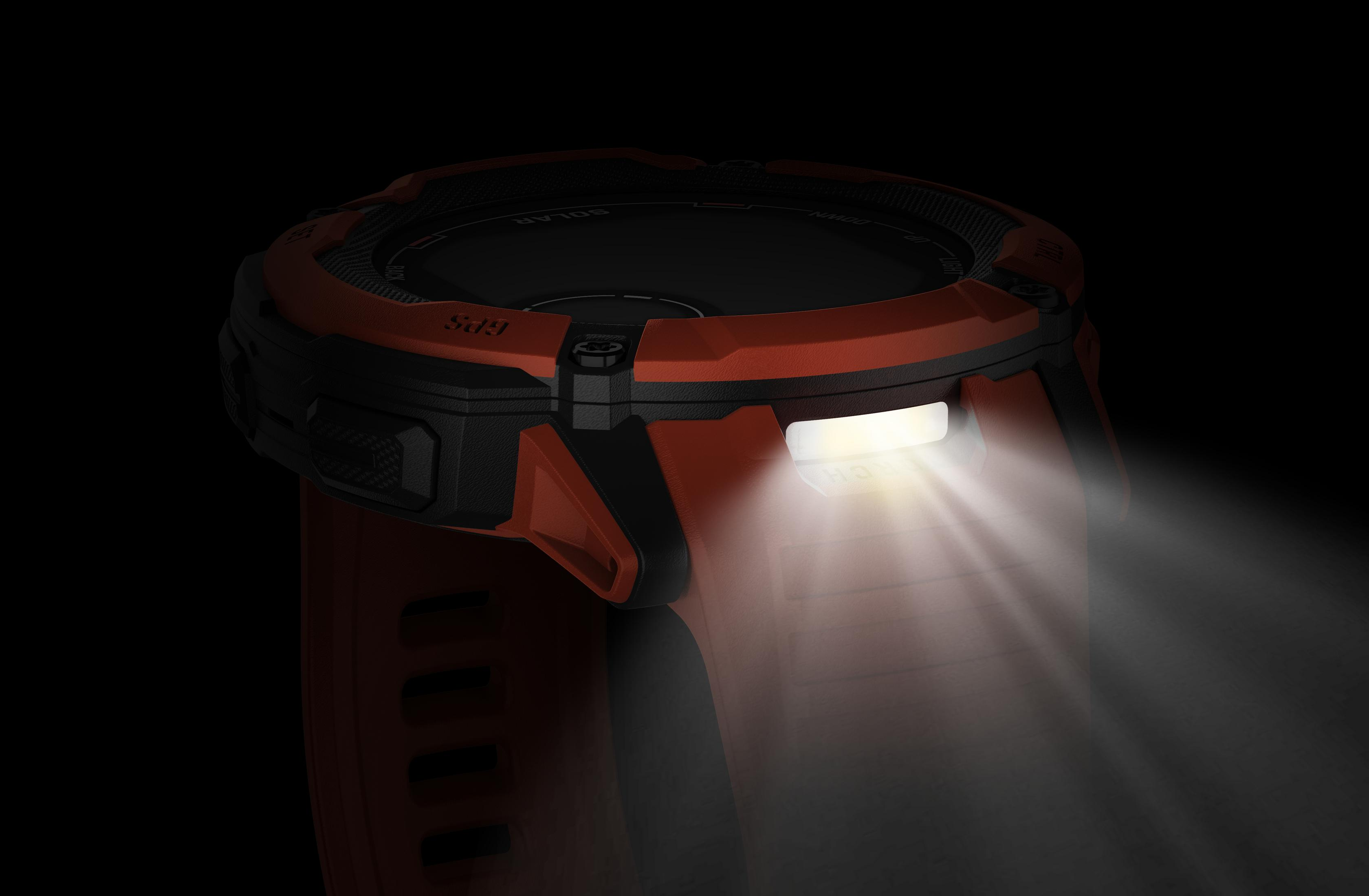 Pomarańczowy i czarny smartwatch z jasnym światłem. Czarne tło.