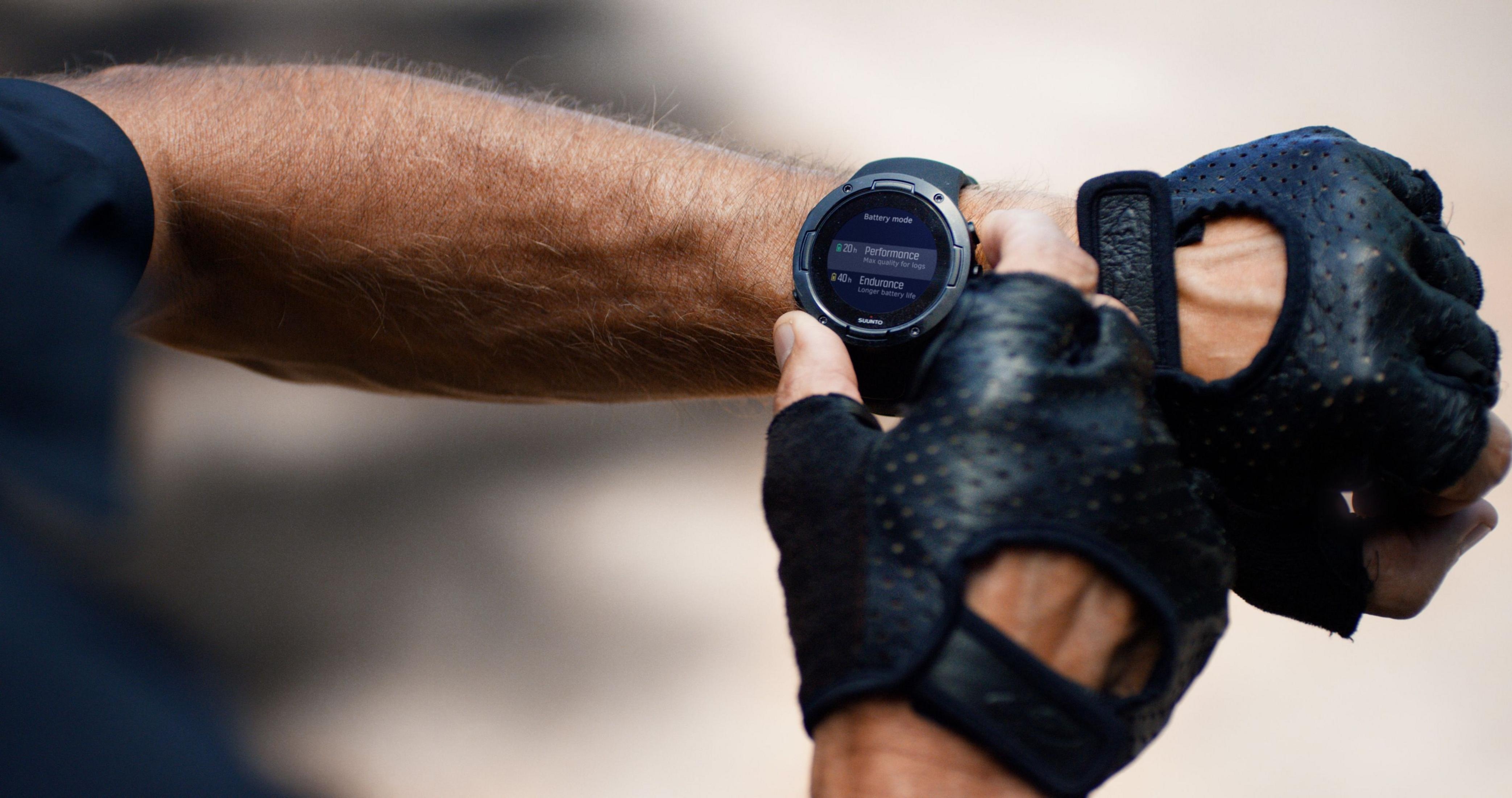 Nahaufnahme einer Smartwatch, die den Batteriemodus und Trainingsdaten am Handgelenk anzeigt.