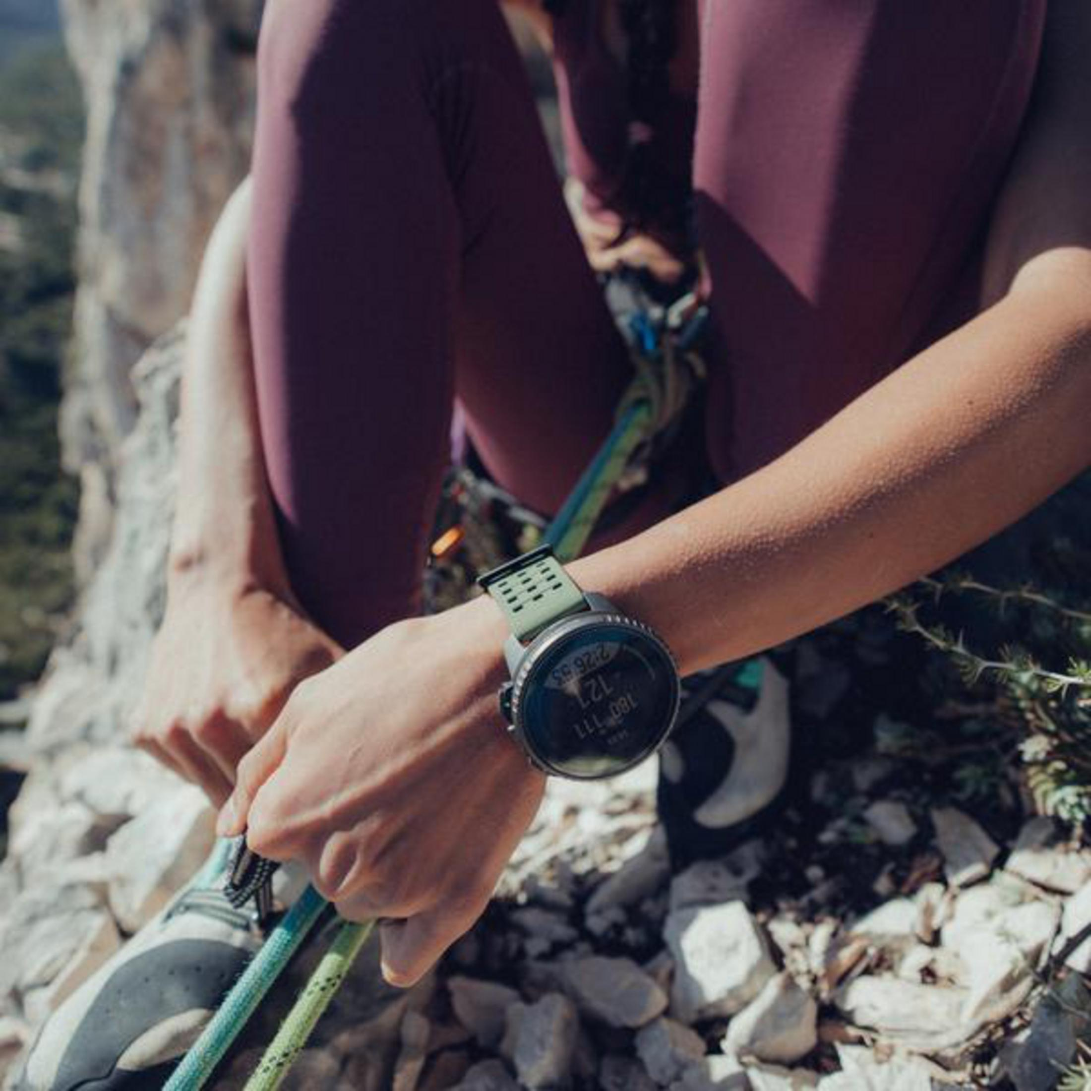 Nahaufnahme einer Uhr am Handgelenk mit Kletterausrüstung.
