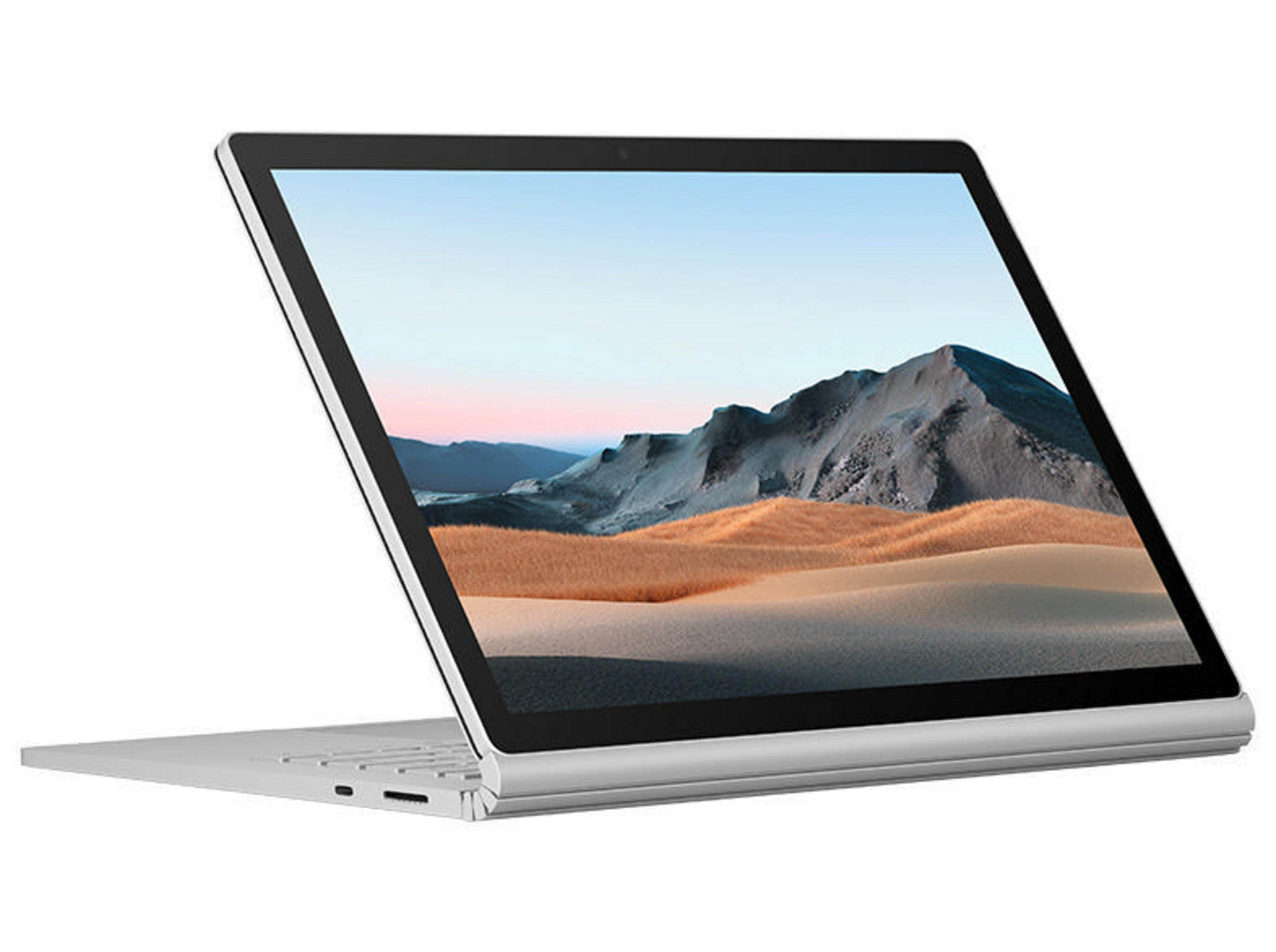 Silberner Laptop, geöffnet, zeigt Landschaftsbild. Weißer Hintergrund, schräge Ansicht.