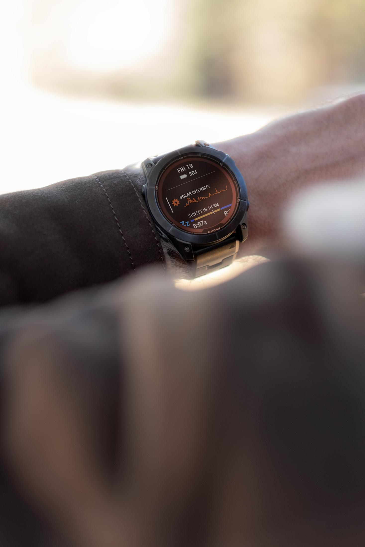 Een persoon die een horloge draagt dat de zonne-intensiteit en andere gegevens weergeeft. Het horloge zit om een pols.