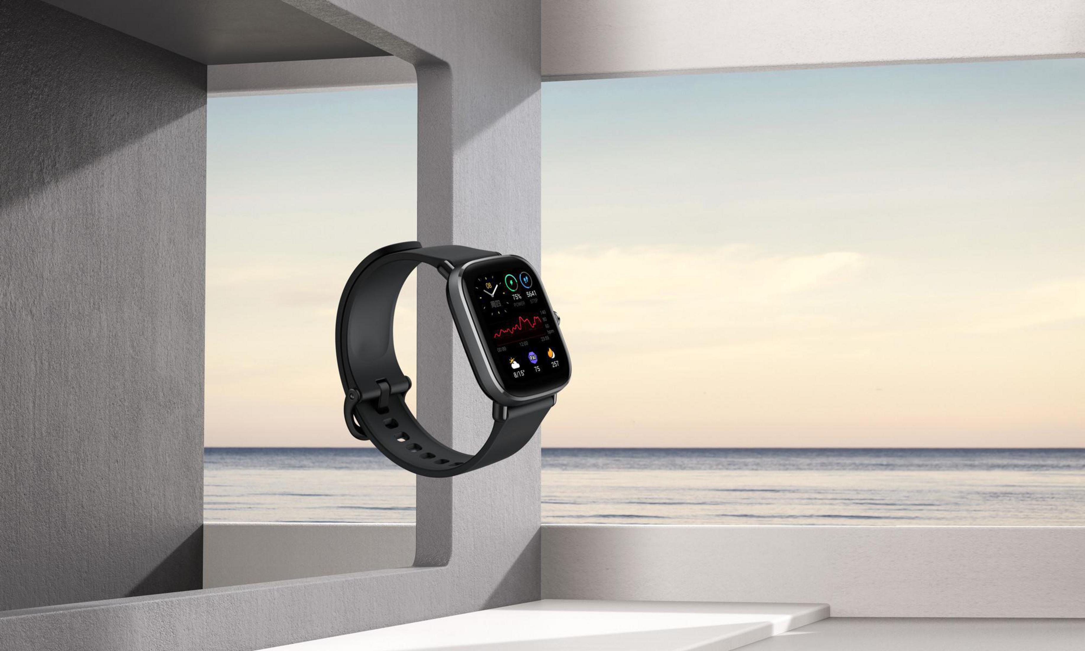 Smartwatch con cinturino nero, mostra dati, fluttuante in un ambiente moderno e minimalista.