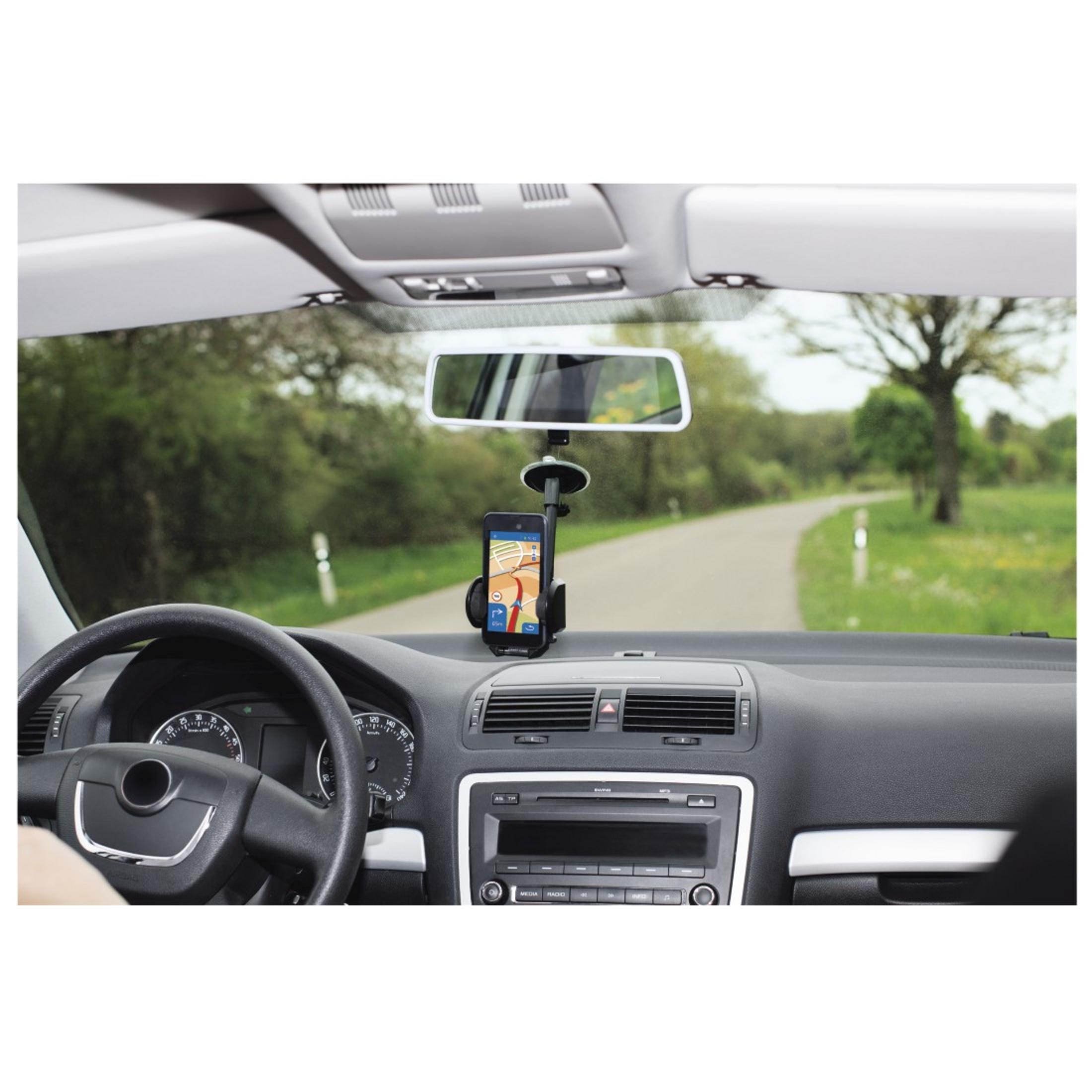 Interno auto con telefono su supporto, mostra mappa GPS, con strada e alberi sullo sfondo.