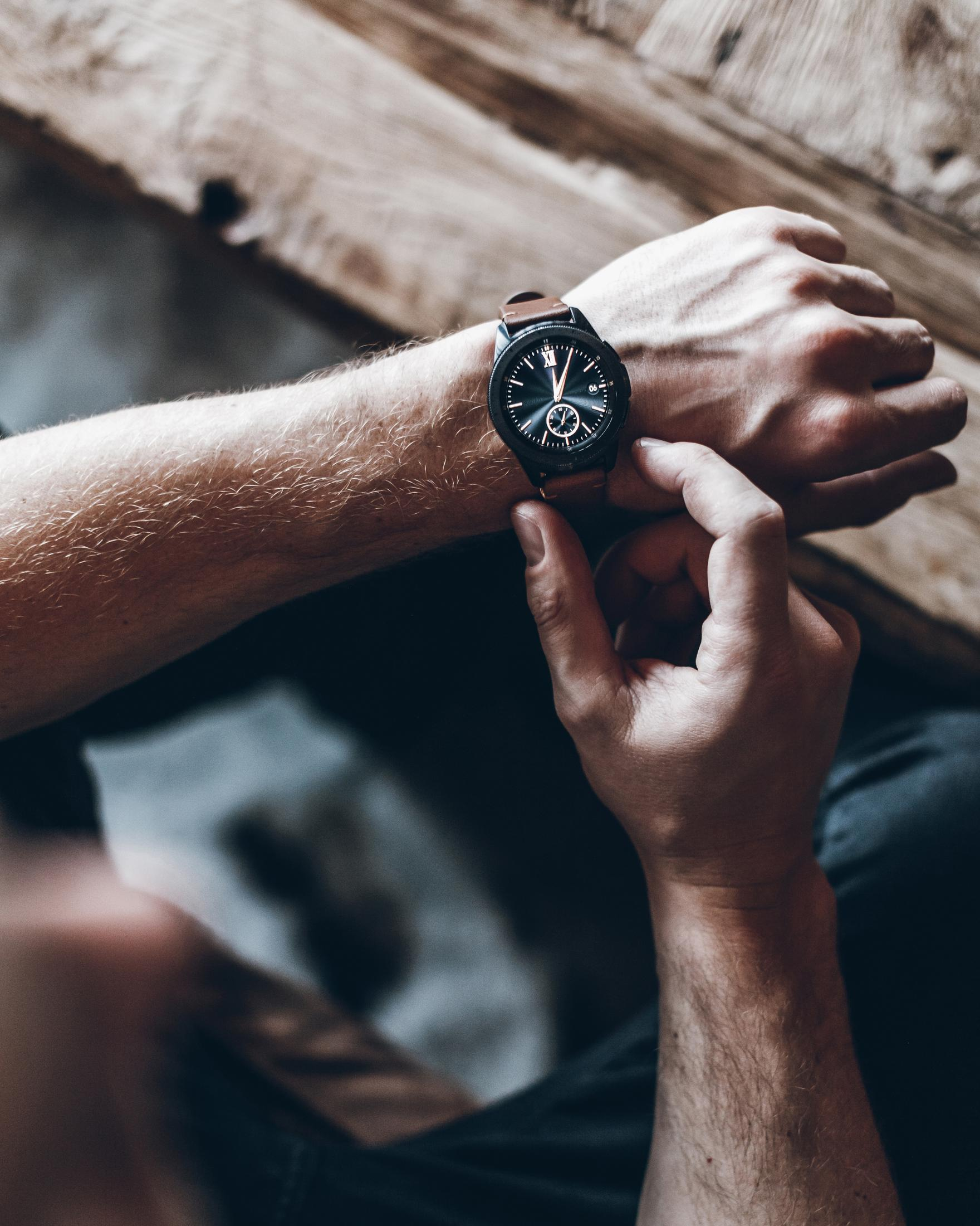 Mannes Hand mit Uhr, braunes Lederband, kontrolliert die Zeit.