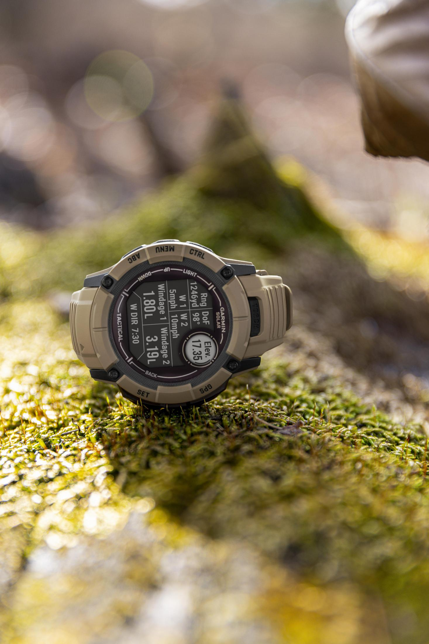 Smartwatch na mchu, pokazujący czas, wysokość i inne dane. Rozmyte tło.