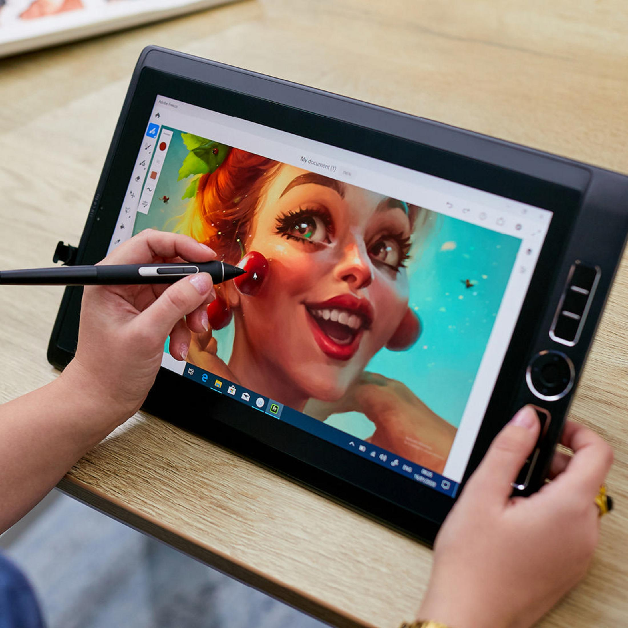Eine Person zeichnet mit einem Stift auf einem Tablet. Das Tablet zeigt einen Cartoon mit einem Frauengesicht.
