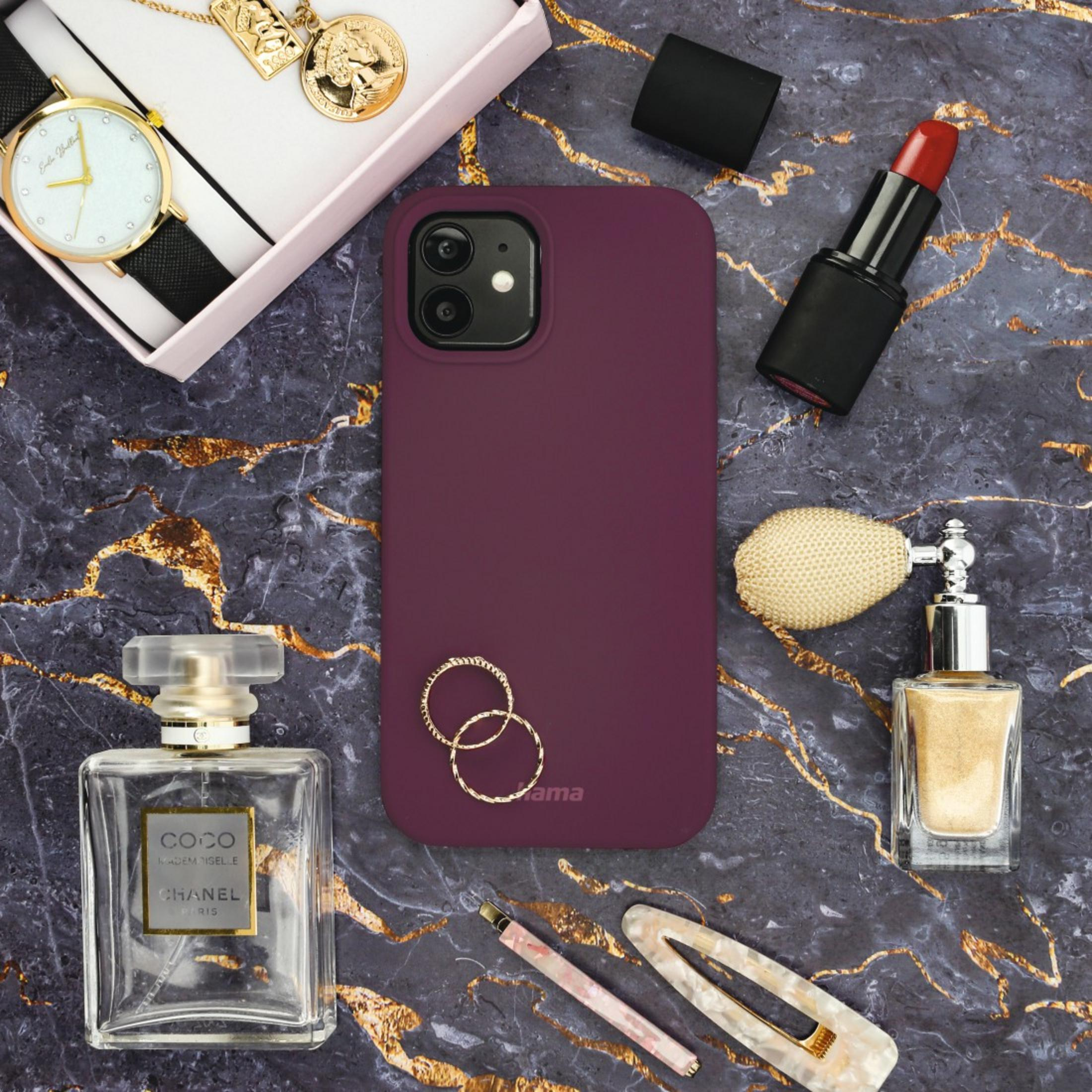 Make-up-Artikel auf Marmoroberfläche: Handyhülle, Lippenstift, Parfüm, Uhr und Accessoires.