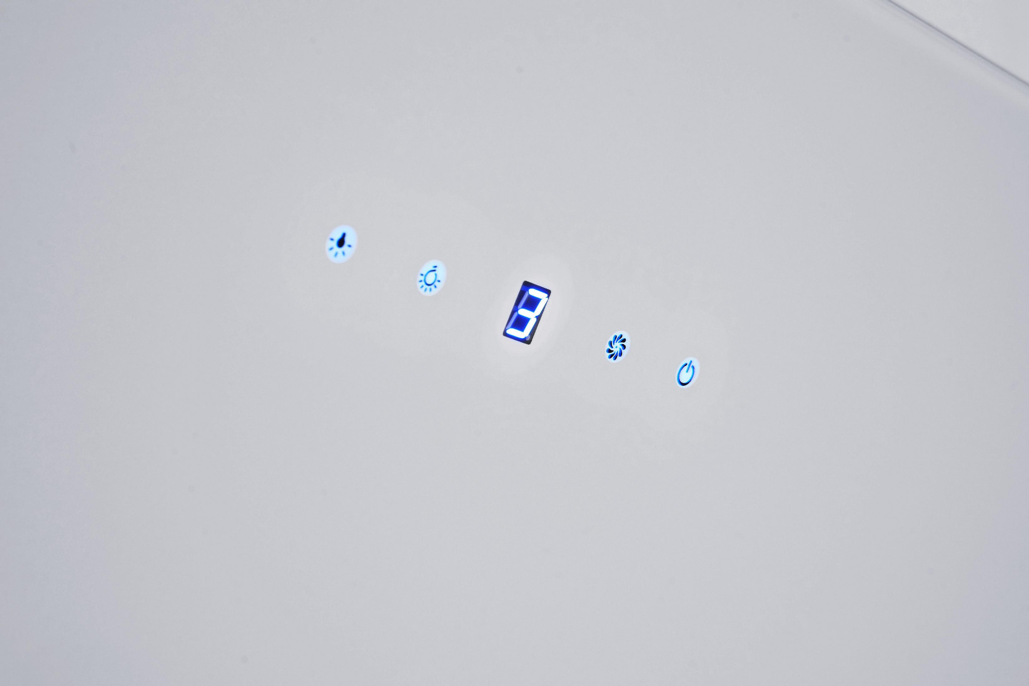 Primo piano di una superficie bianca con icone di visualizzazione digitale illuminate di blu.