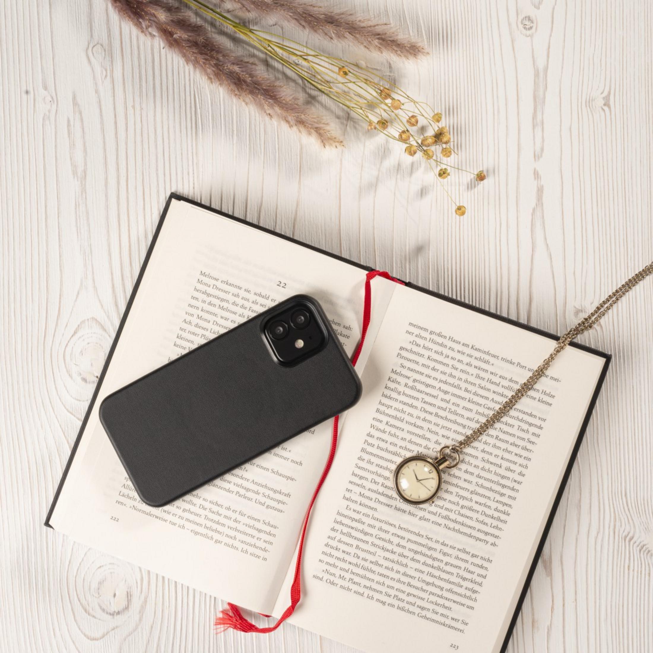 Czarny telefon, zegarek na łańcuszku i książka leżą na drewnianej powierzchni.