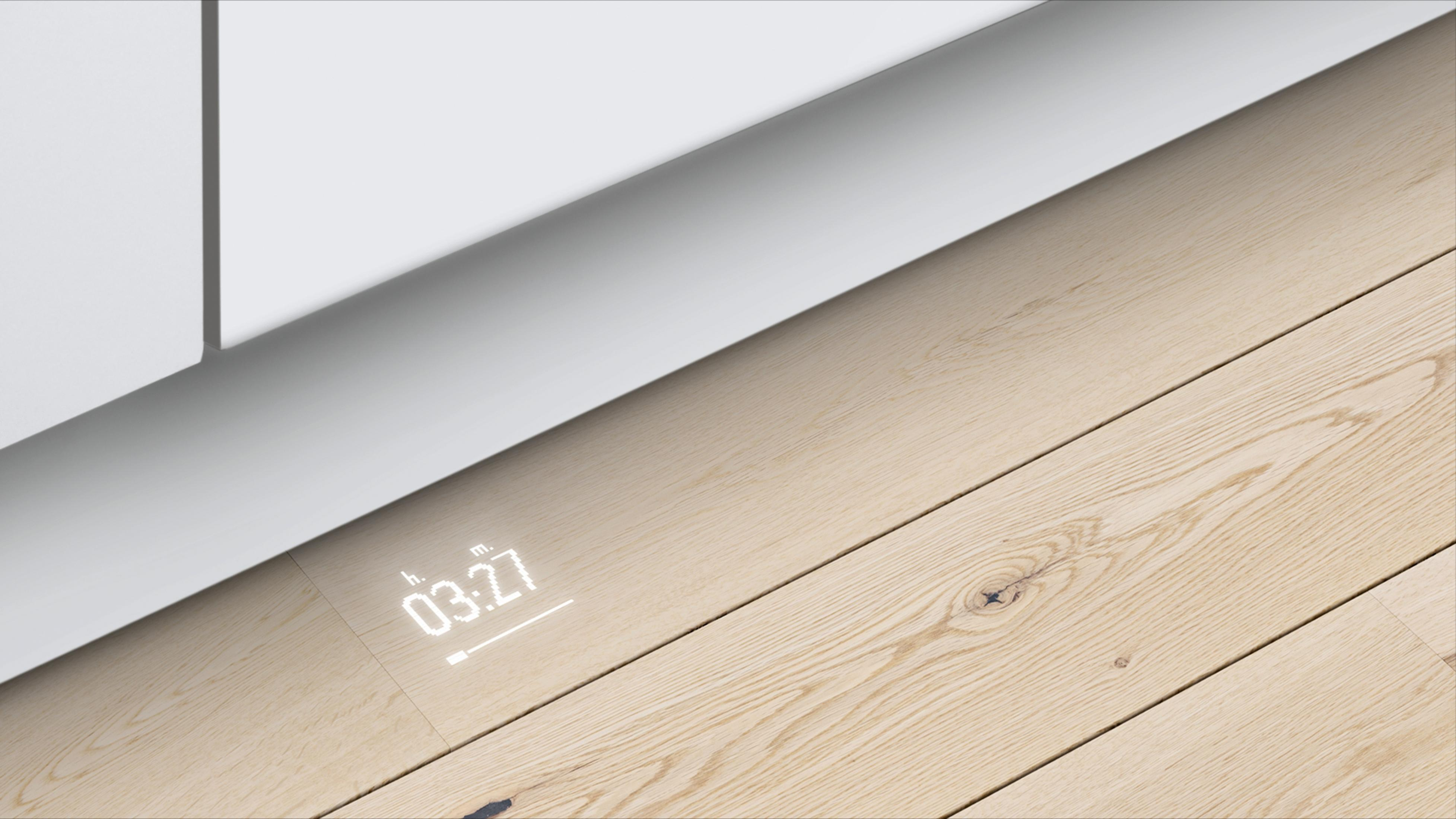 Digitale timerweergave op houten vloer, met 03:27 minuten. Dichtbij een witte plint.