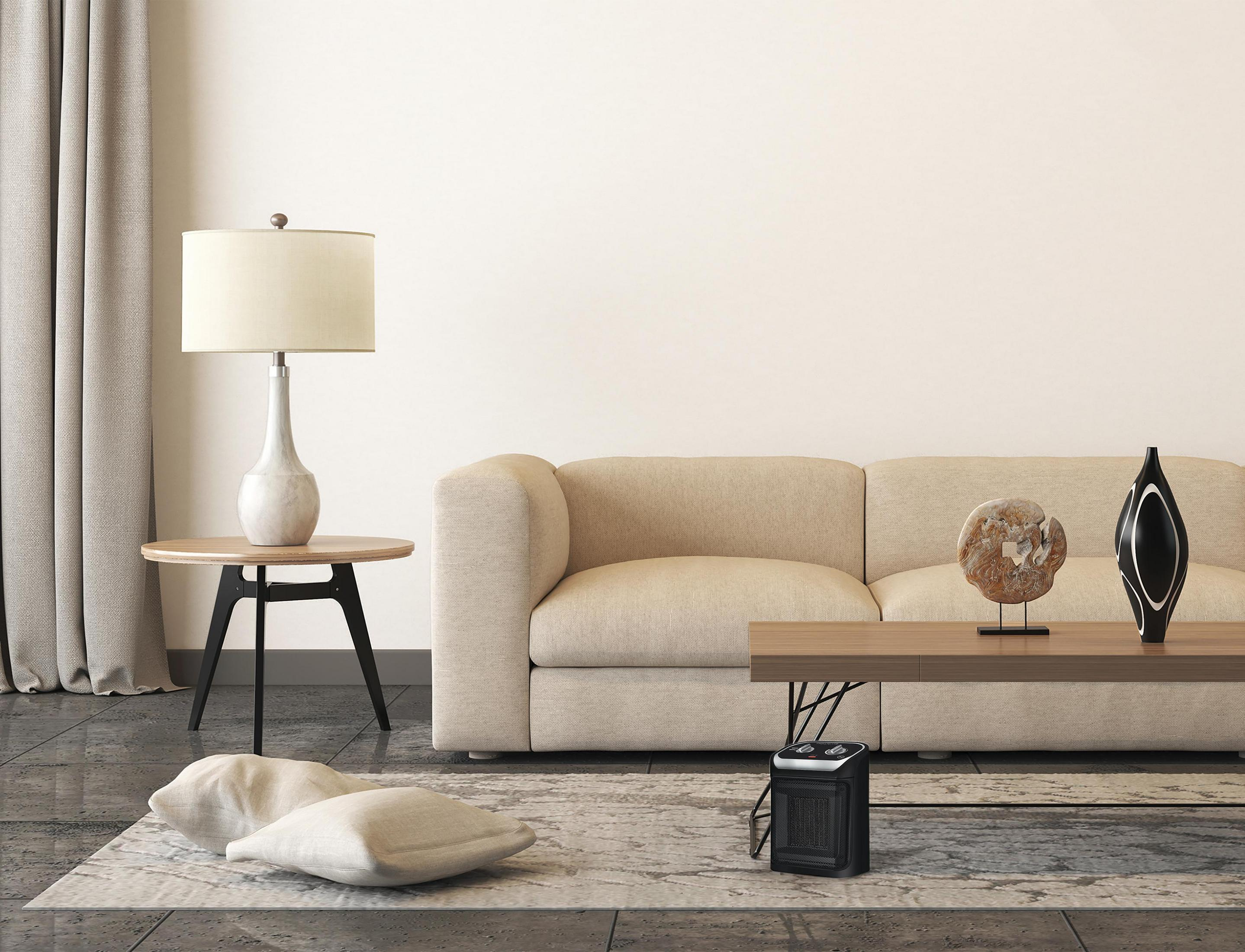 Salon z kanapą, stołem, lampą i grzejnikiem.