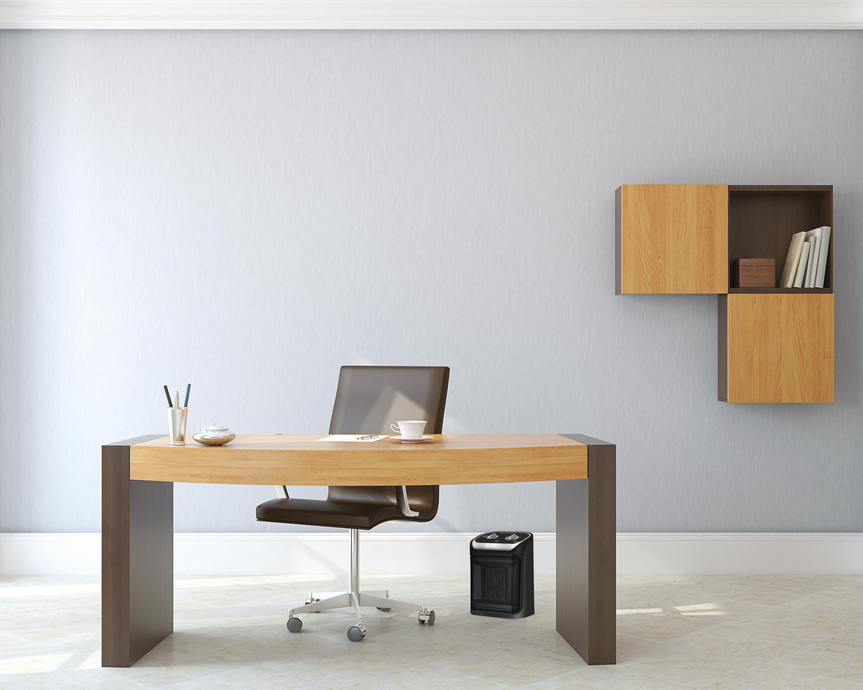 Biuro ze stołem, krzesłem i grzejnikiem. Półka z przedmiotami na ścianie.