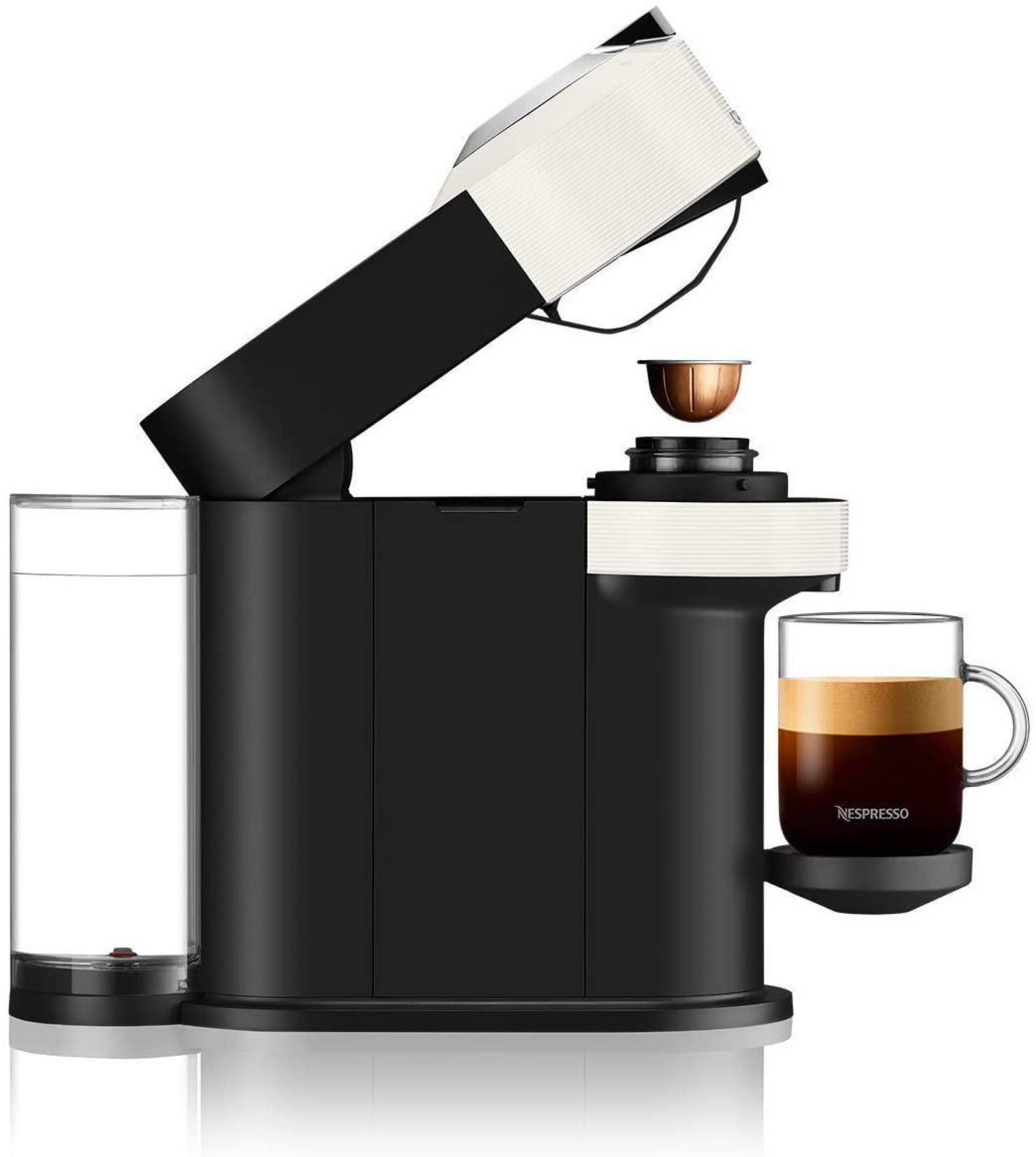 Una cafetera Nespresso en blanco y negro con una taza de café. Se está insertando una cápsula.