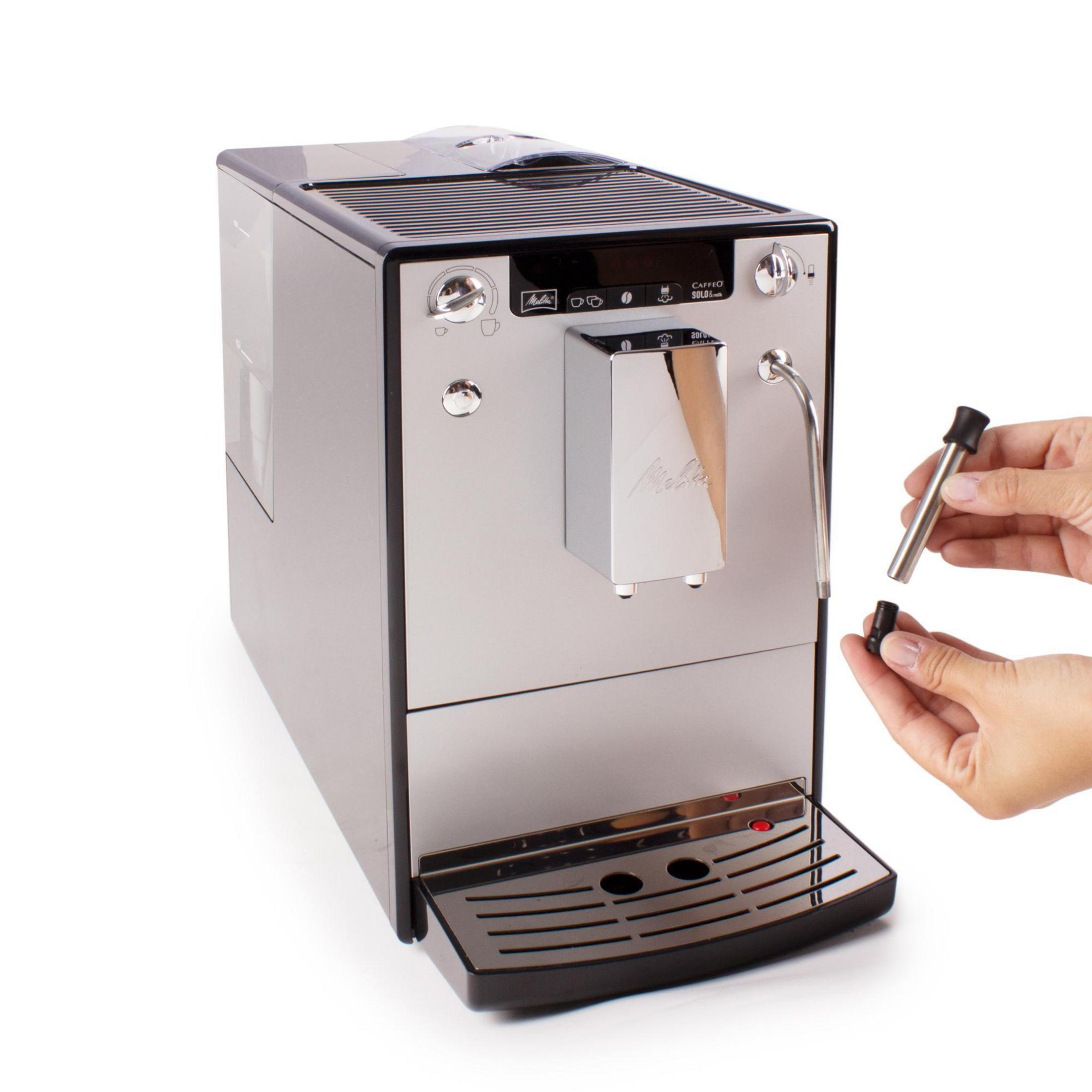 Silber-schwarze Kaffeemaschine. Eine Hand hält den Kaffeeauslauf.