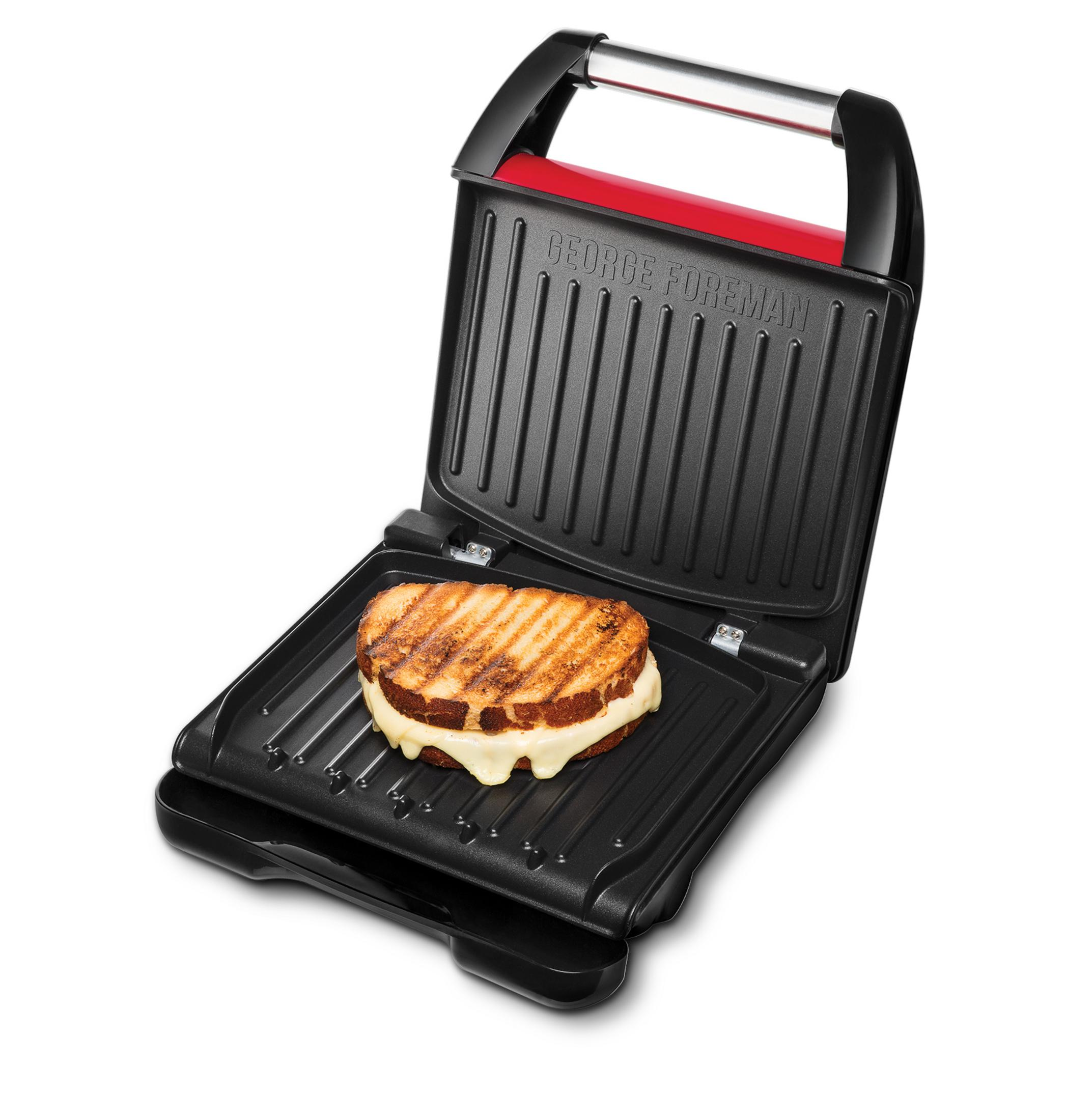 Parrilla George Foreman con un sándwich de queso a la plancha. La parrilla es negra con un asa roja.