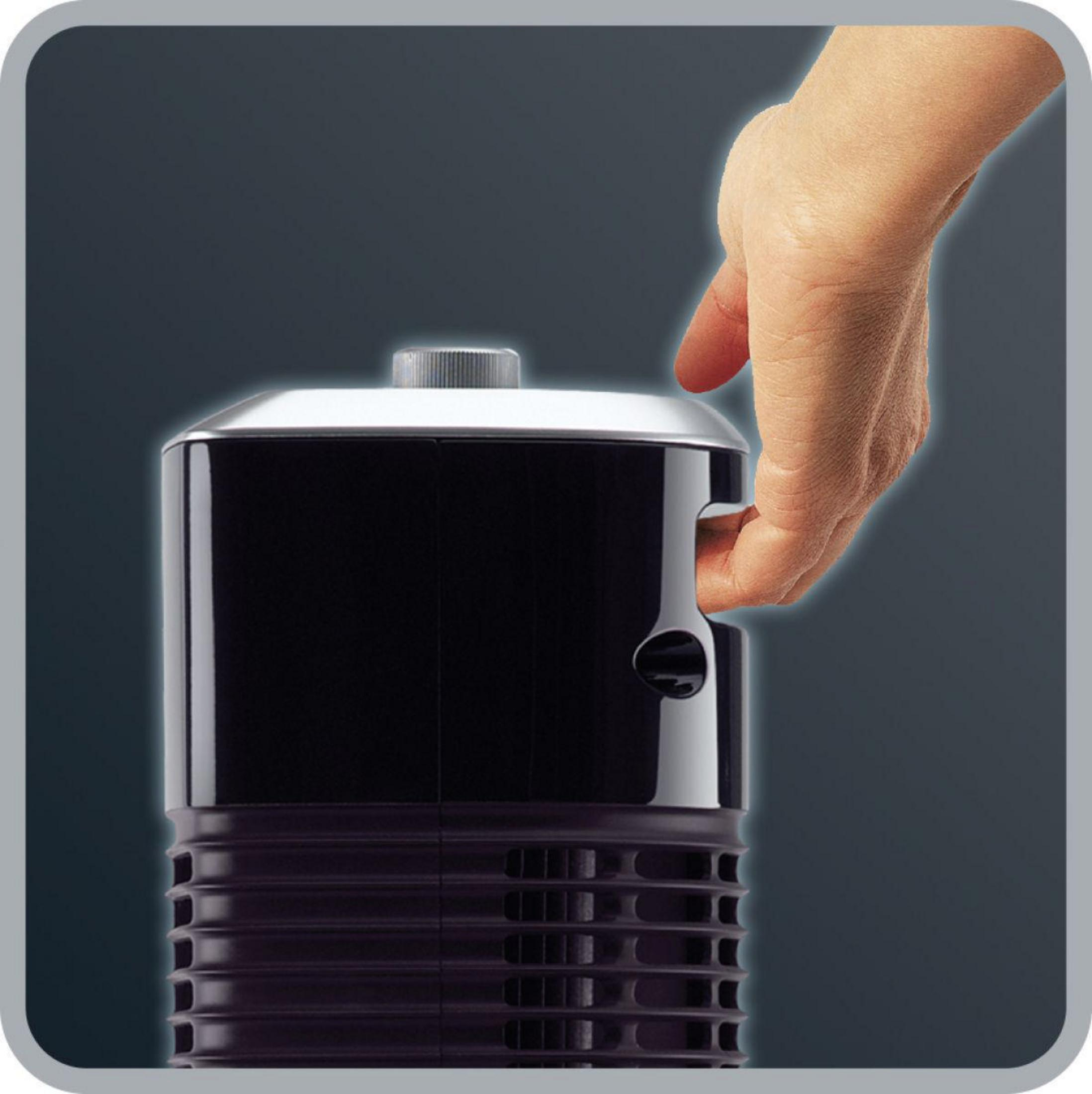 Una mano presionando un botón en un dispositivo negro con la parte superior plateada.