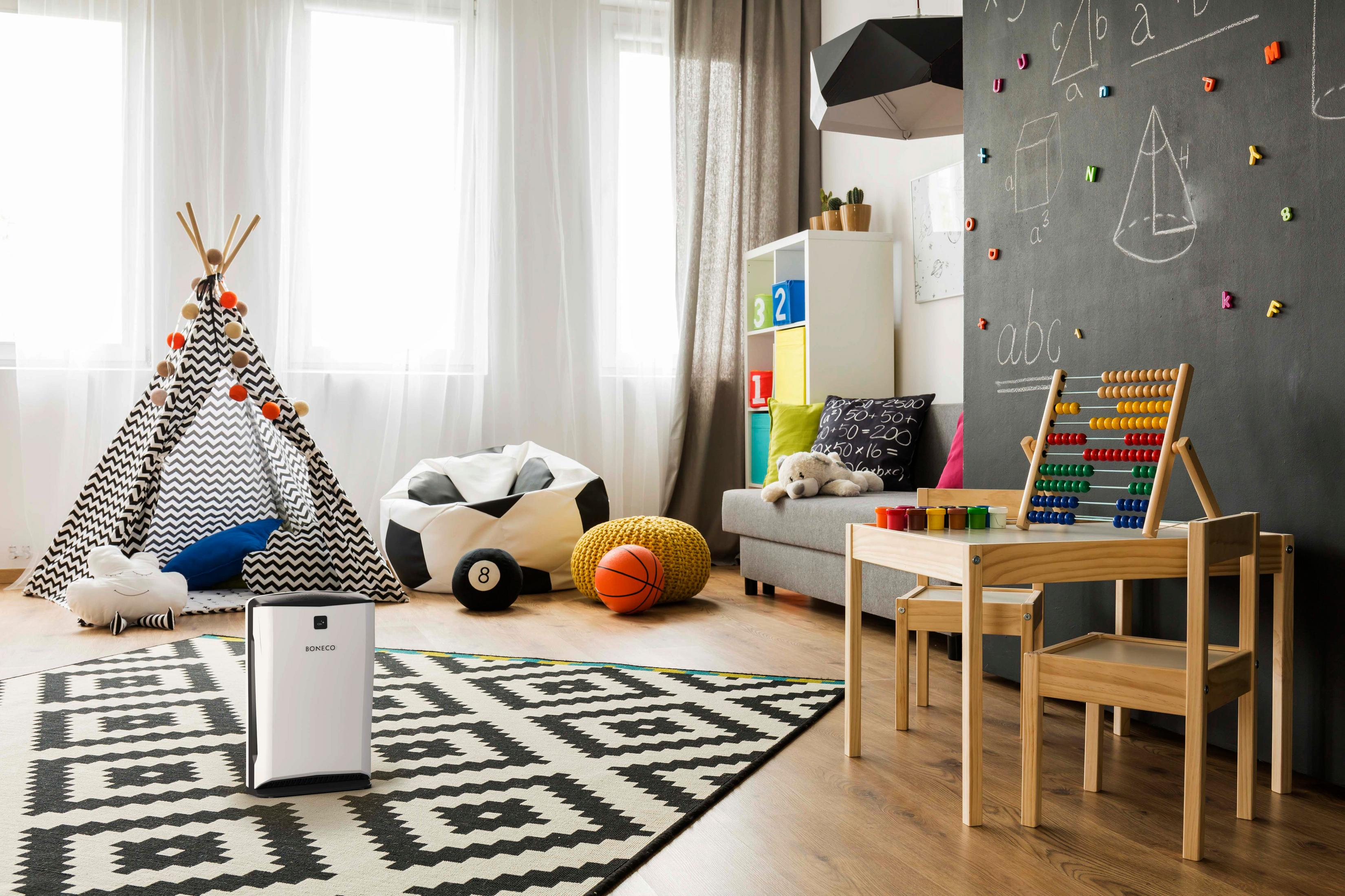 Stanza giochi per bambini con teepee, abaco, tavolo da gioco, tappeto e purificatore d'aria.